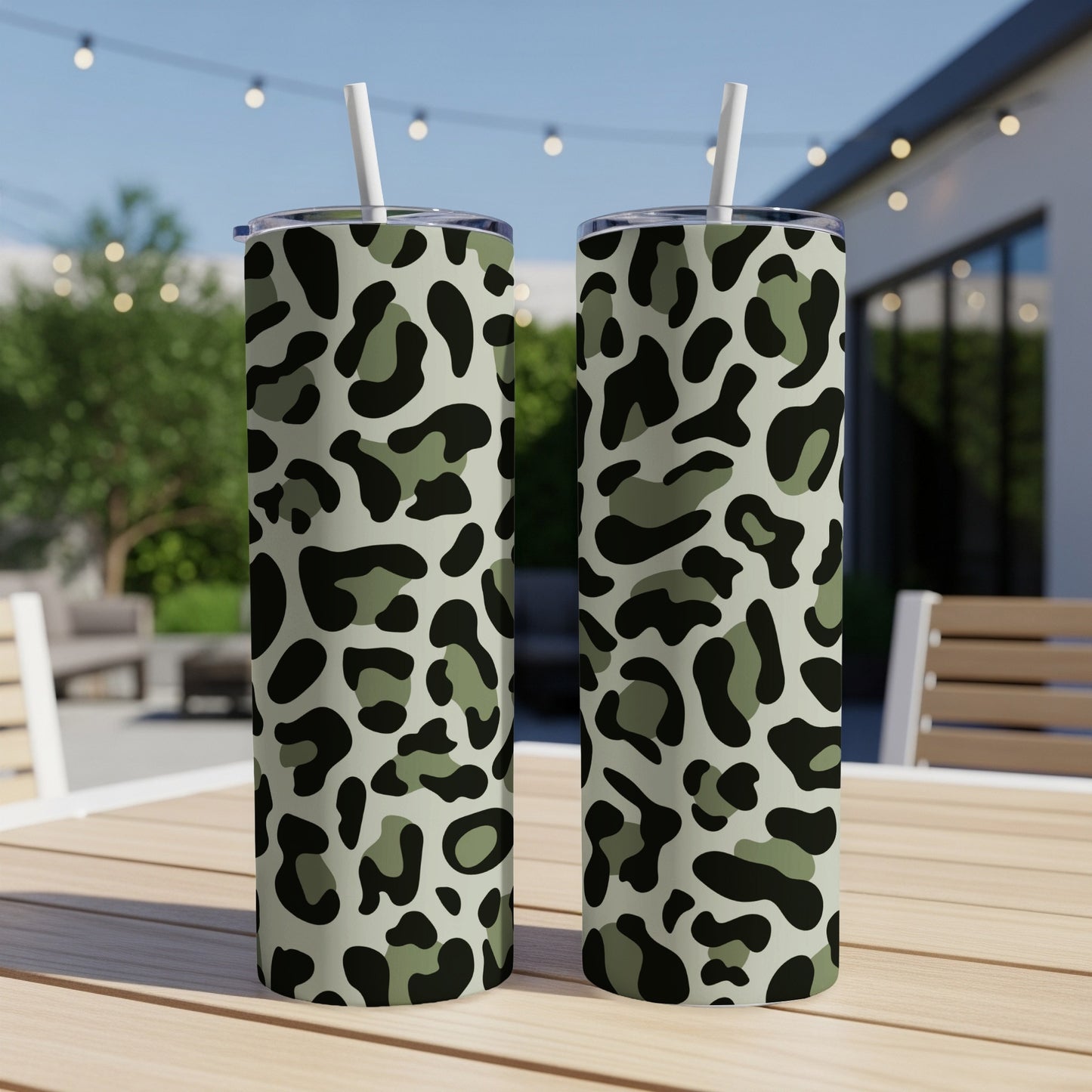 Two tall tumblers with a camouflage-style leopard print pattern on a wooden table.