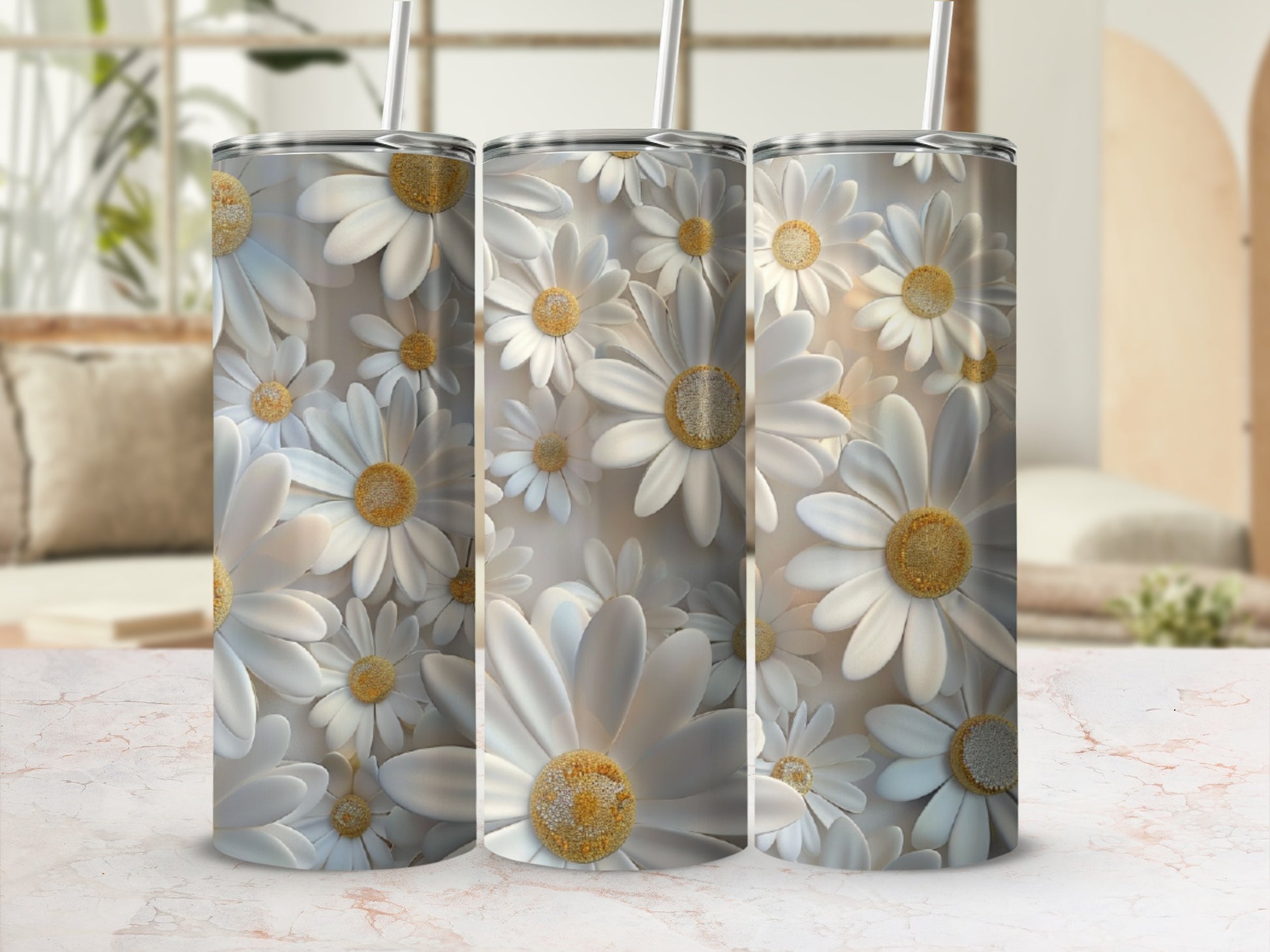Three tumblers covered in white daisies with yellow centers stand in a line.