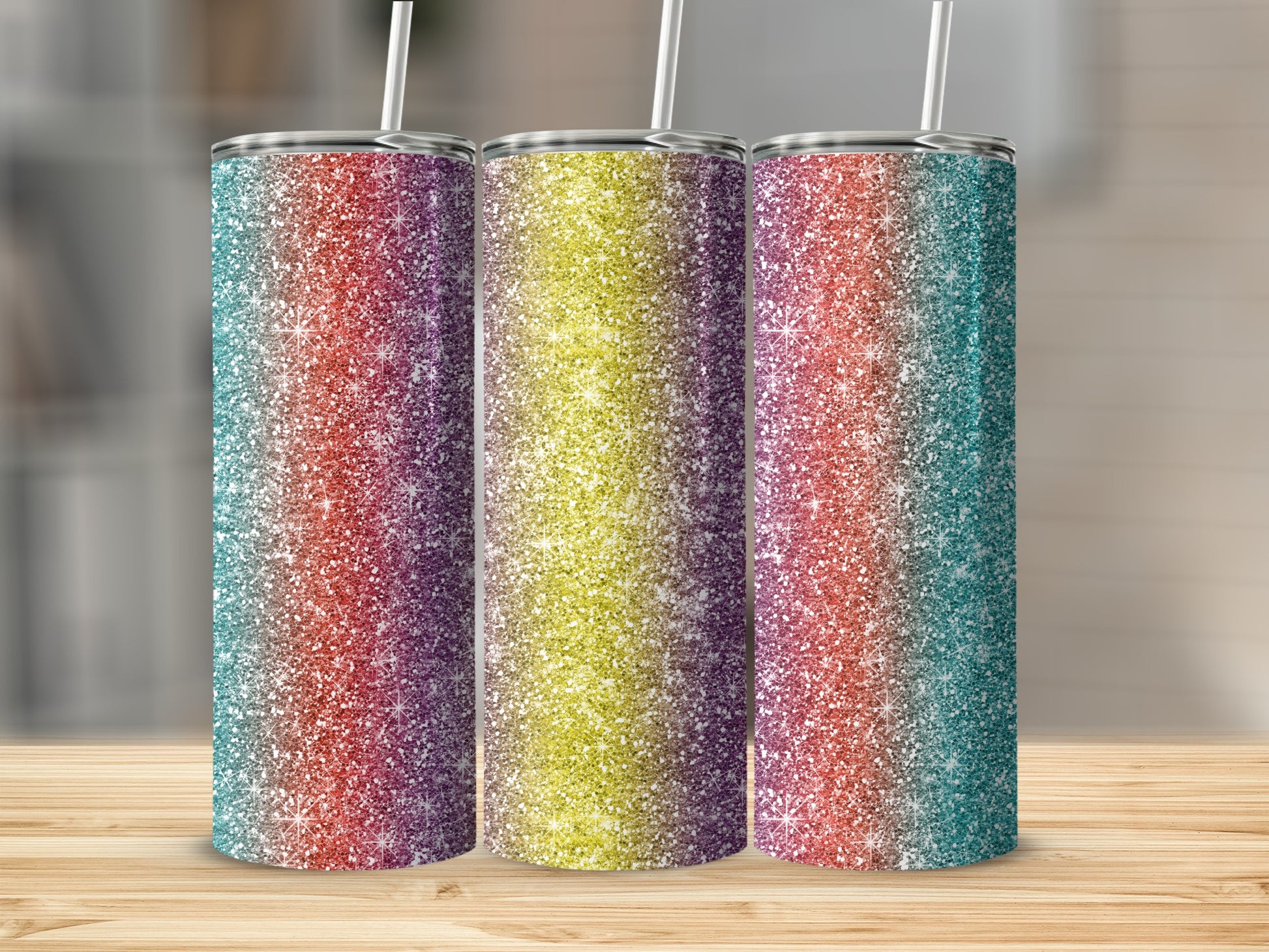 Three glitter tumblers with rainbow gradient patterns on a wooden surface.