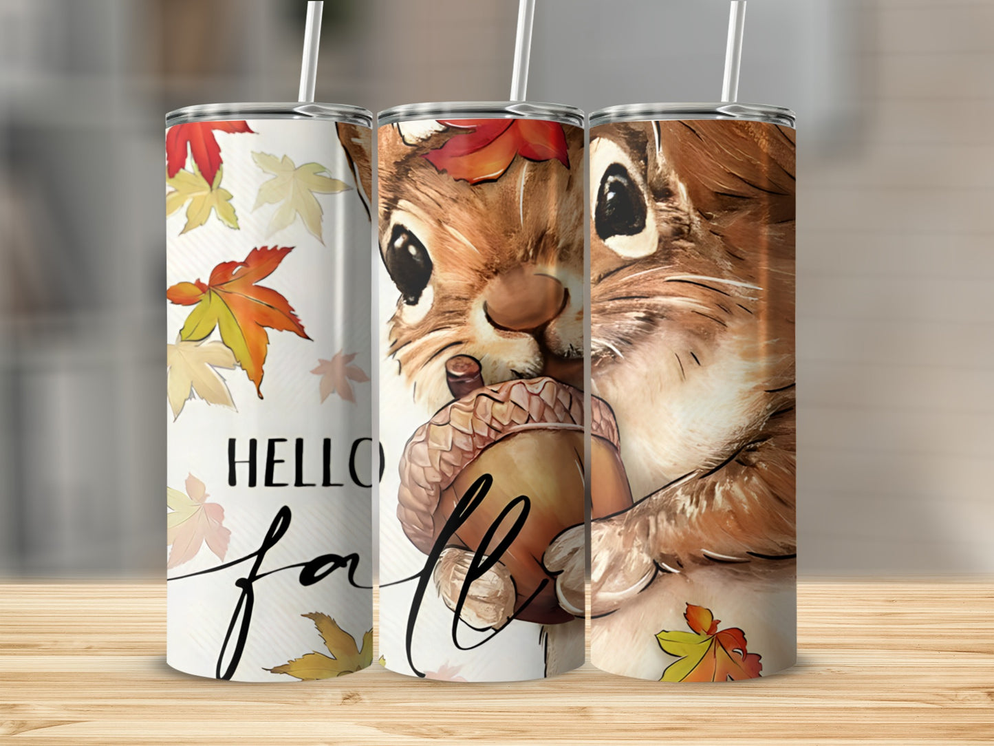 Squirrel holding acorn with "Hello Fall" text on a tumbler.