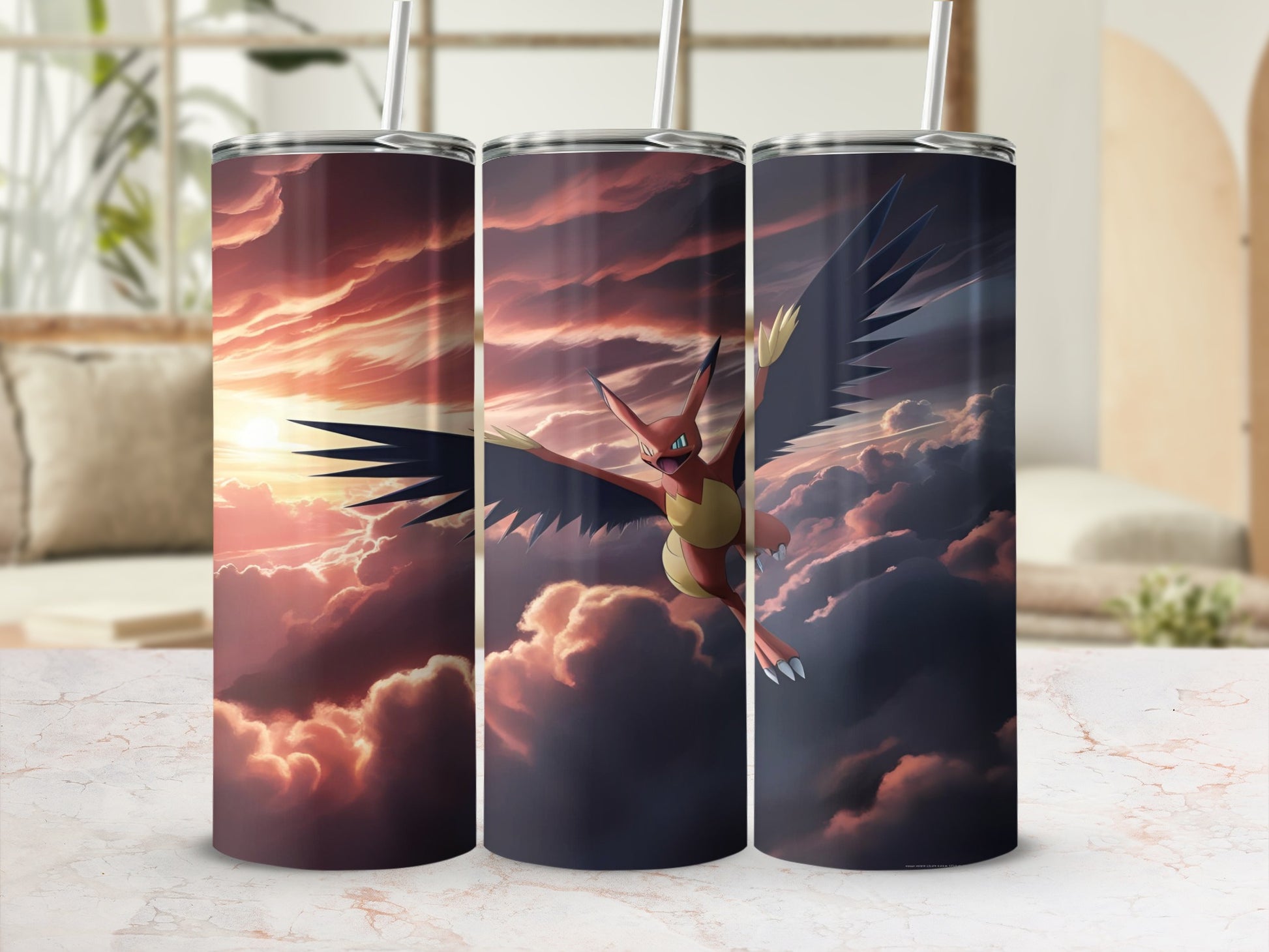 Three Pokémon tumblers with fiery bird creature against a sunset sky.