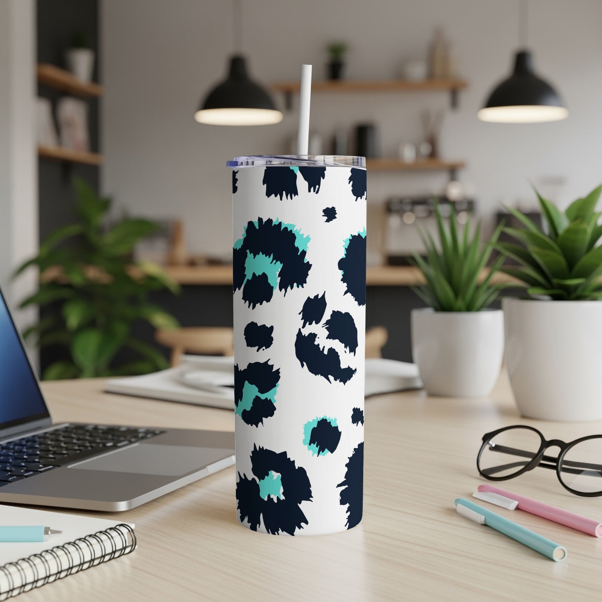 White tumbler with navy and teal leopard print and a white straw.