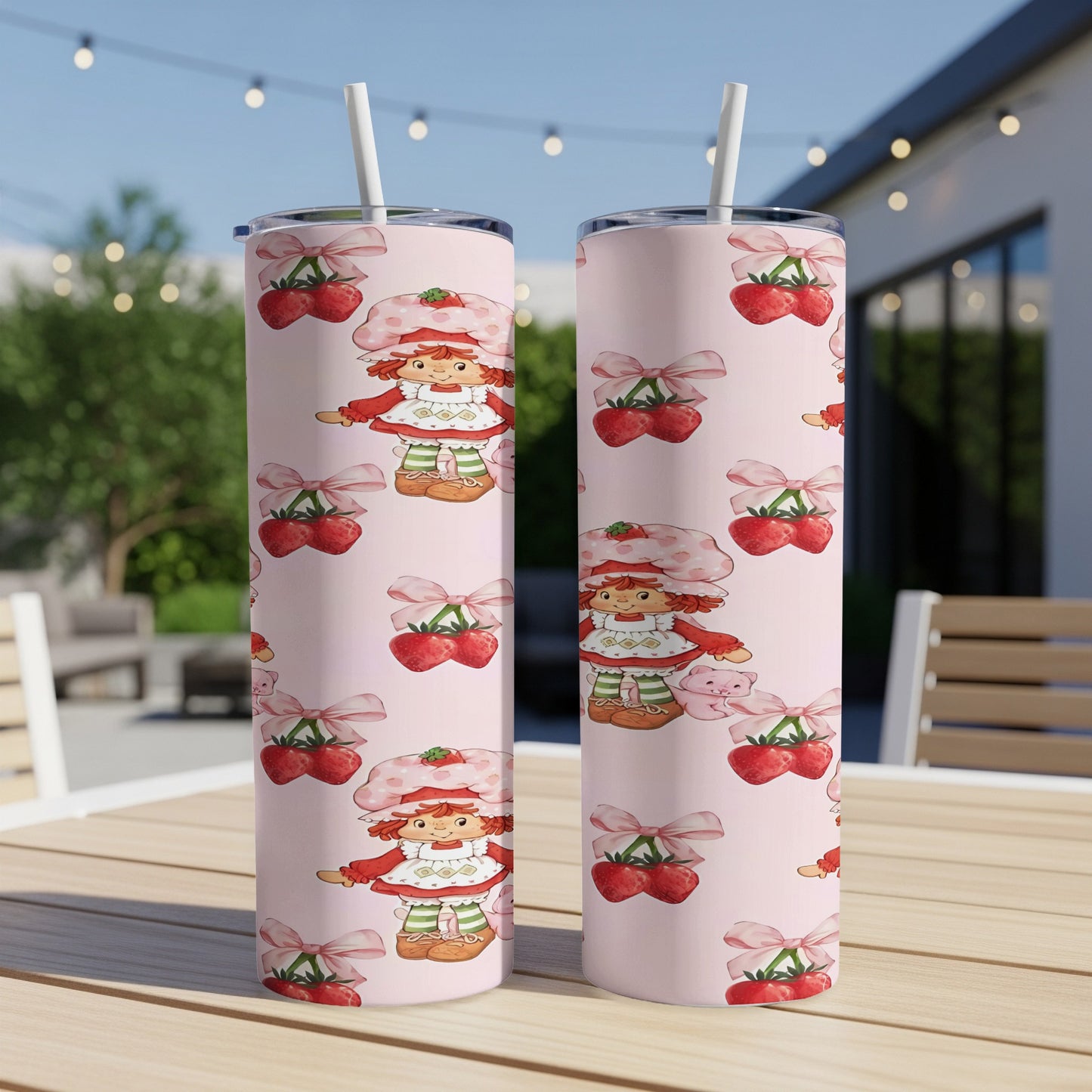 Two pink tumblers with a repeating pattern of Strawberry Shortcake and cherries.