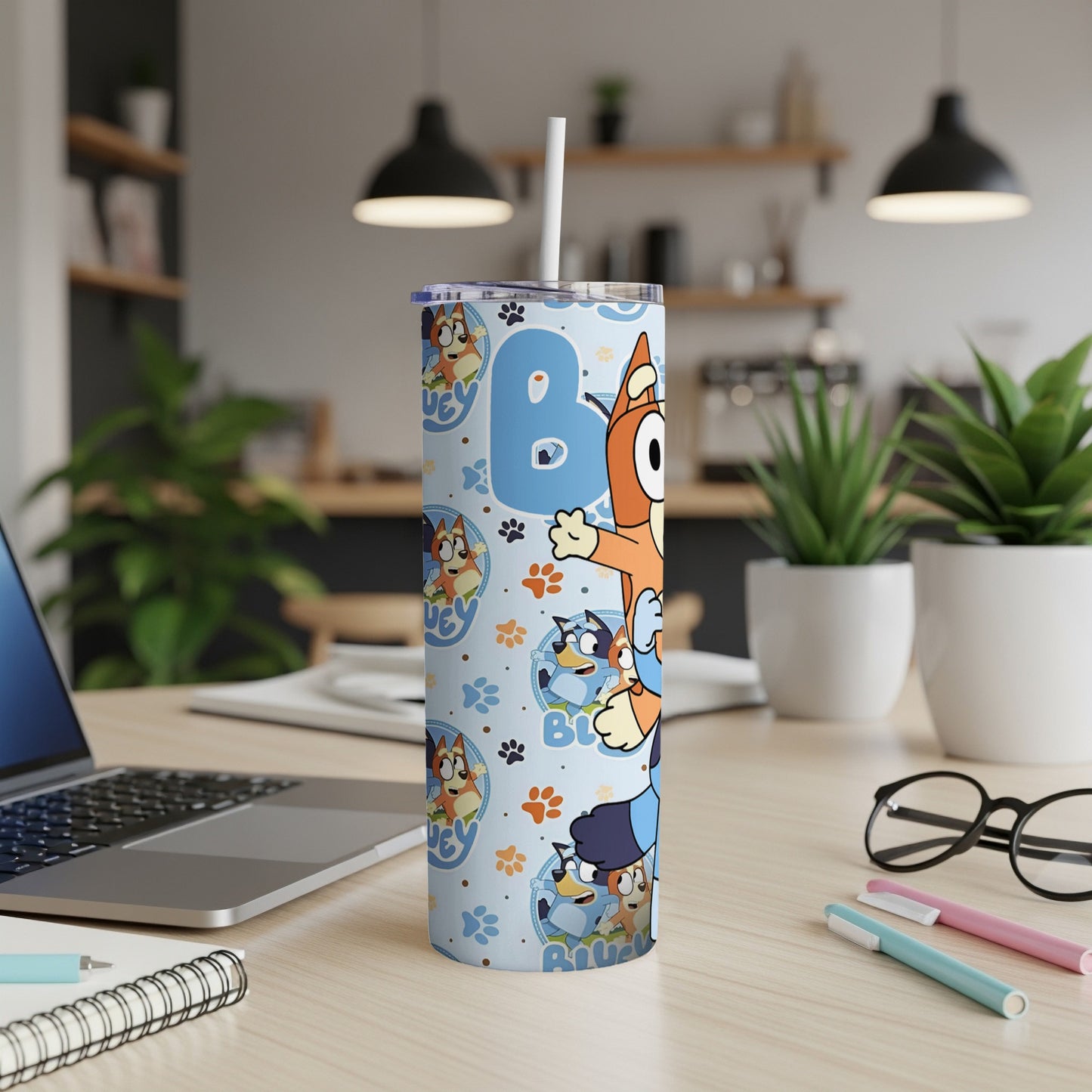 Bluey characters and paw prints on a tall, insulated tumbler with a straw.