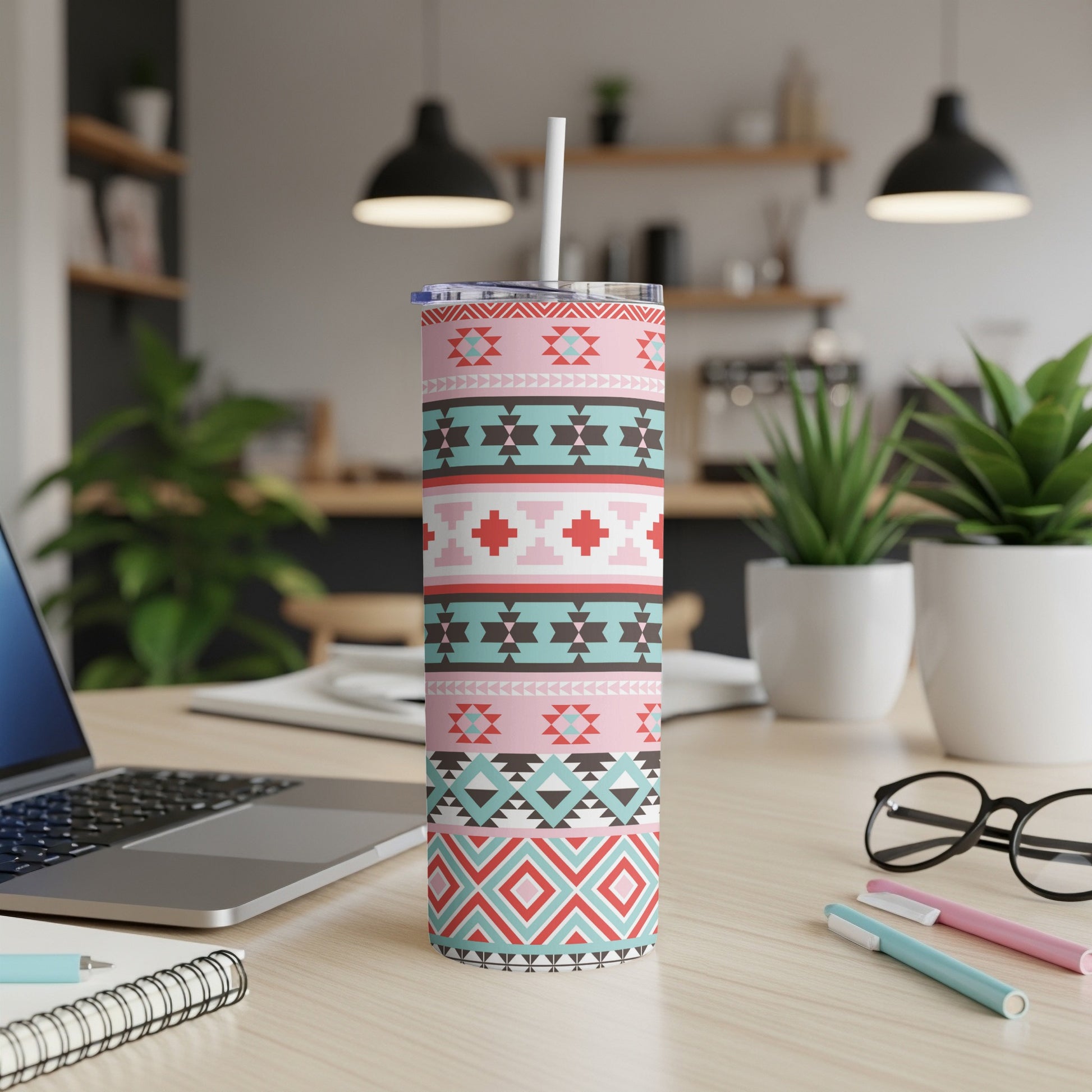 Tall tumbler with pink and geometric patterns, featuring a straw.