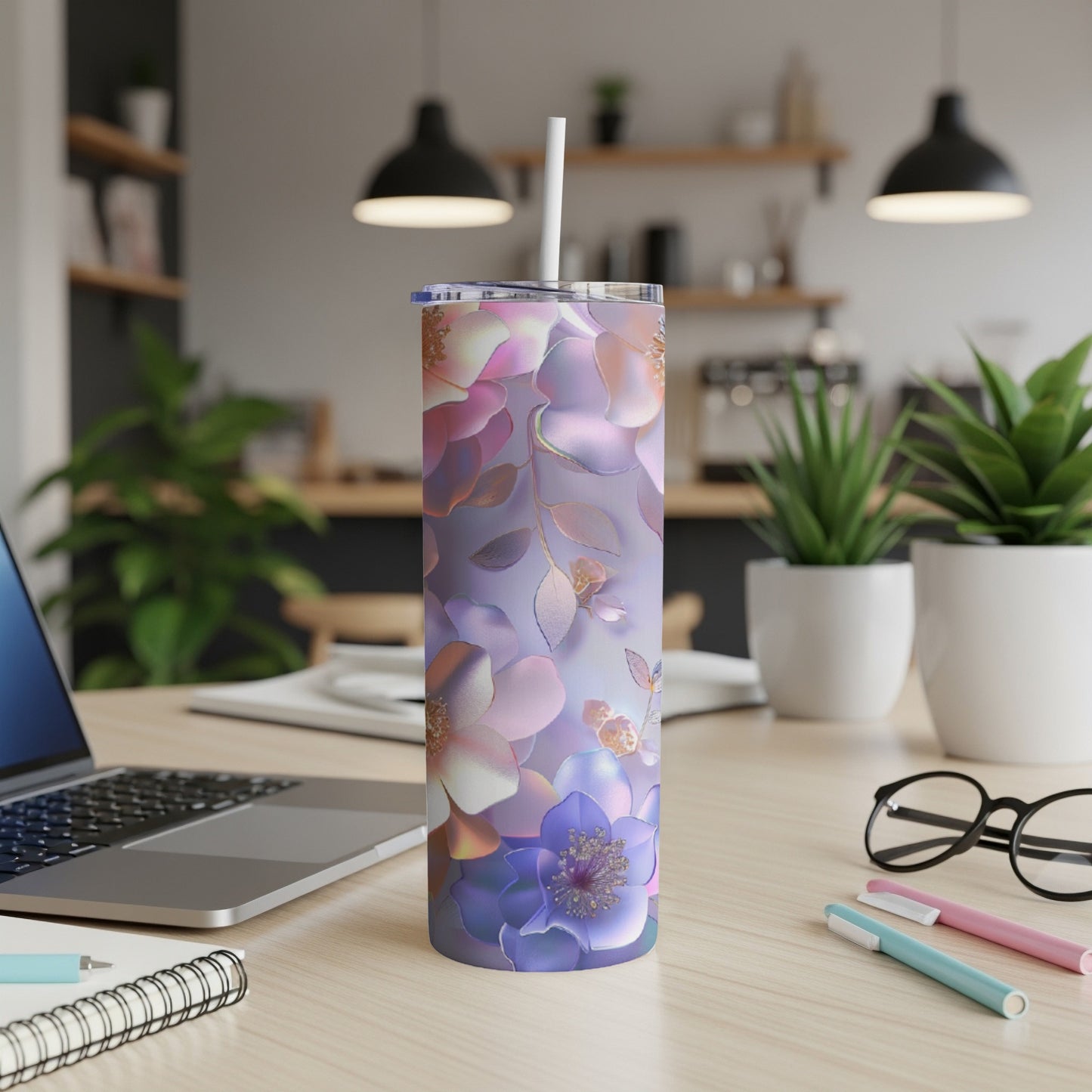 Floral pattern tumbler with straw on a desk with laptop.
