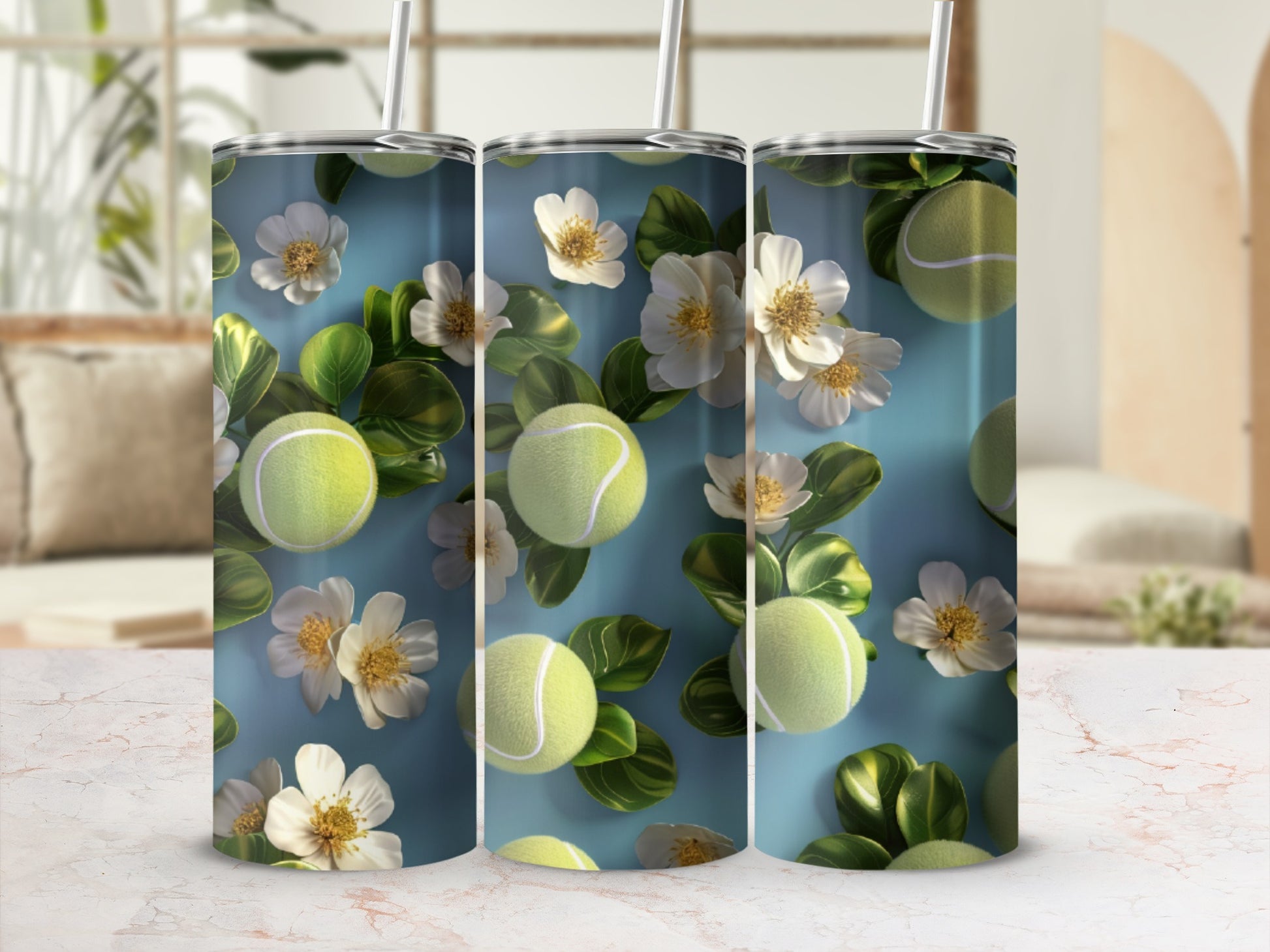 Three tumblers with tennis balls and white flowers on a blue background.