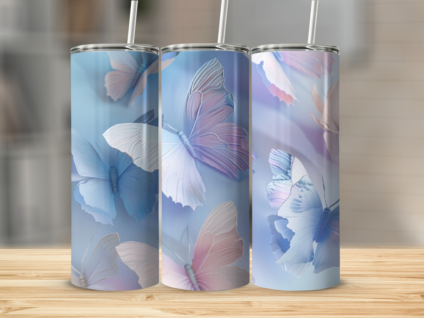 Three tall tumblers with pastel butterflies on a light blue background.