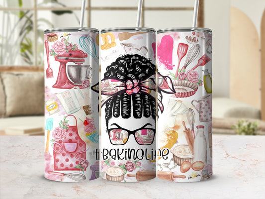 Woman with messy bun wearing glasses, surrounded by baking ingredients and tools.