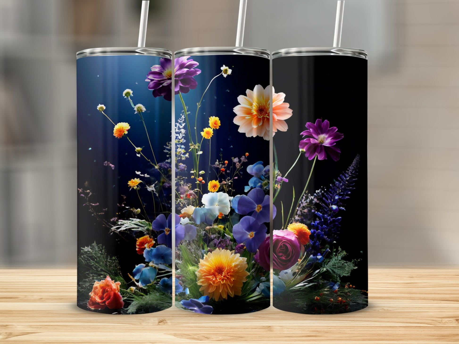 Three tumblers featuring colorful floral arrangements against a dark background.