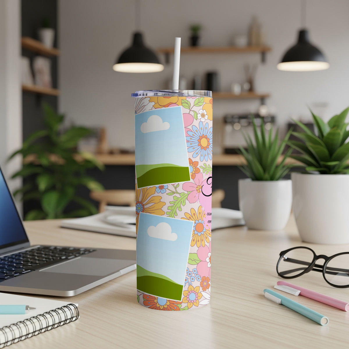 Floral tumbler with photo frames and "CON" text, on a desk.