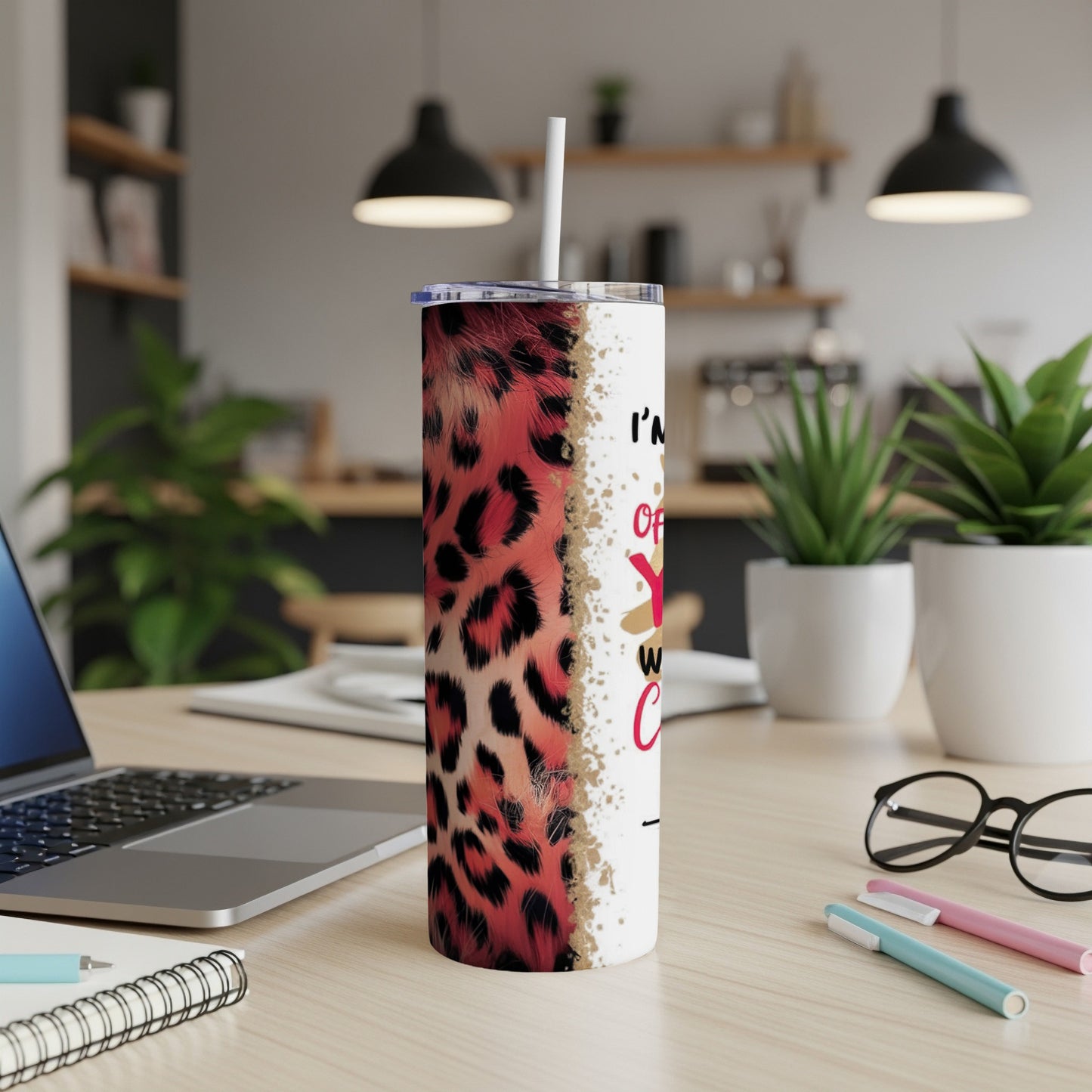 Leopard print tumbler with white lettering on a desk.