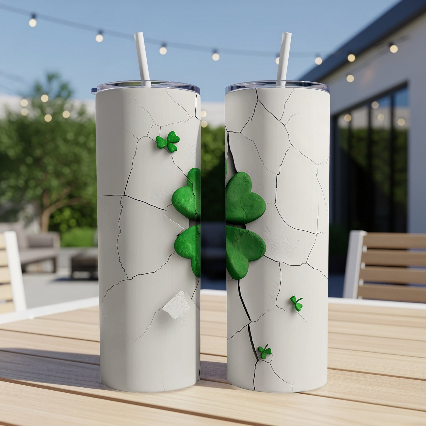 Cracked white tumbler with green shamrocks on a wooden table outdoors.