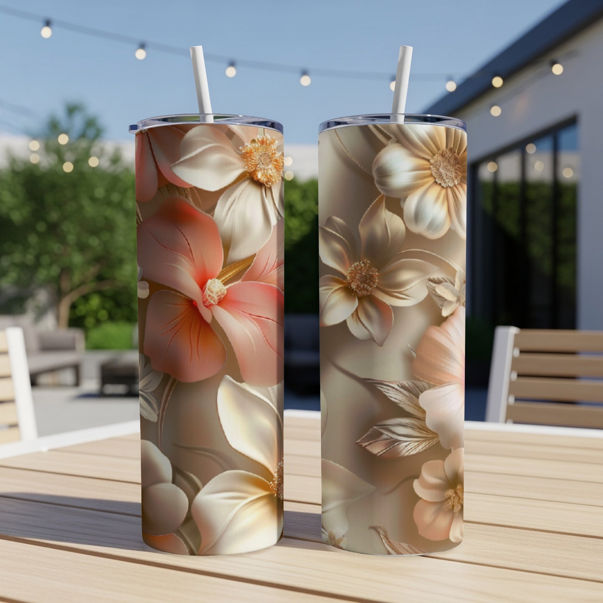 Two tumblers with floral patterns and straws sit on a table.