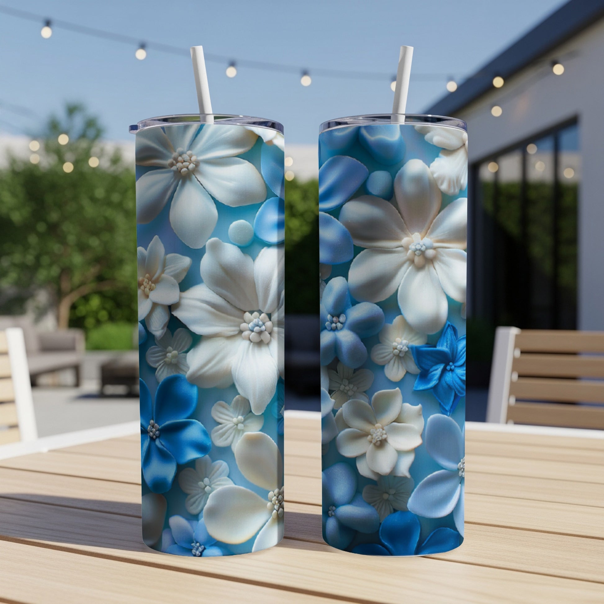 Two tall tumblers with blue and white floral patterns on a table.
