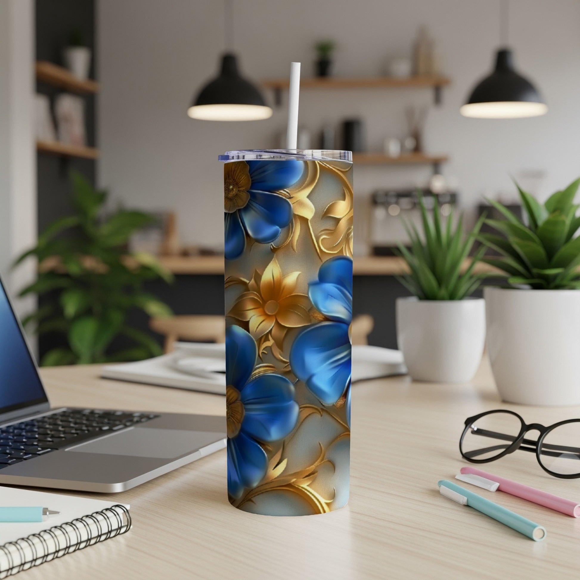 Blue and gold floral pattern on a stainless steel tumbler with a straw.