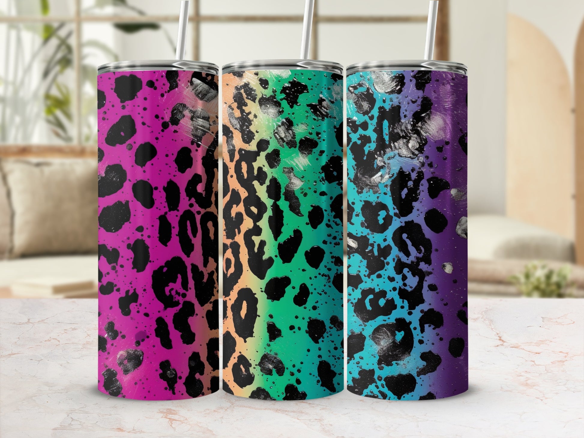 Three leopard print tumblers with rainbow and black paint splatters.