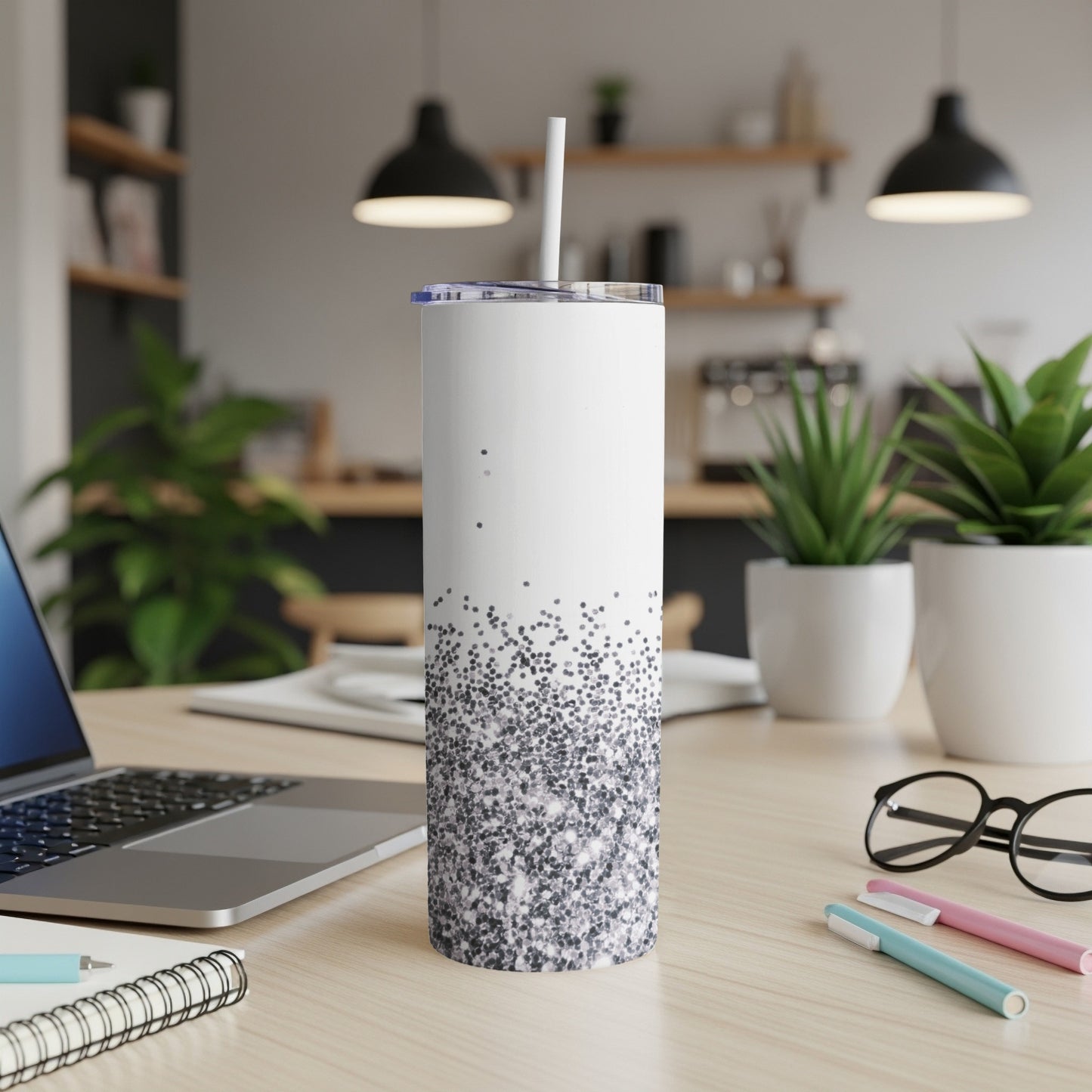 White tumbler with subtle glitter gradient design on a desk.