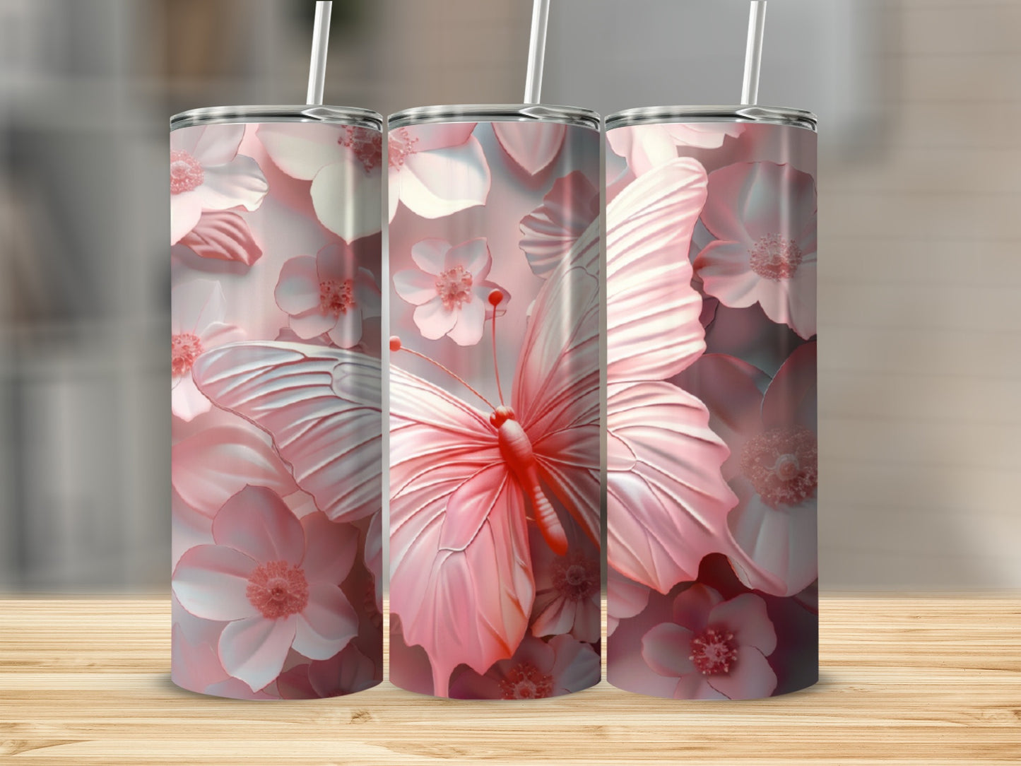 Three pink butterfly and floral tumblers on a wooden surface.