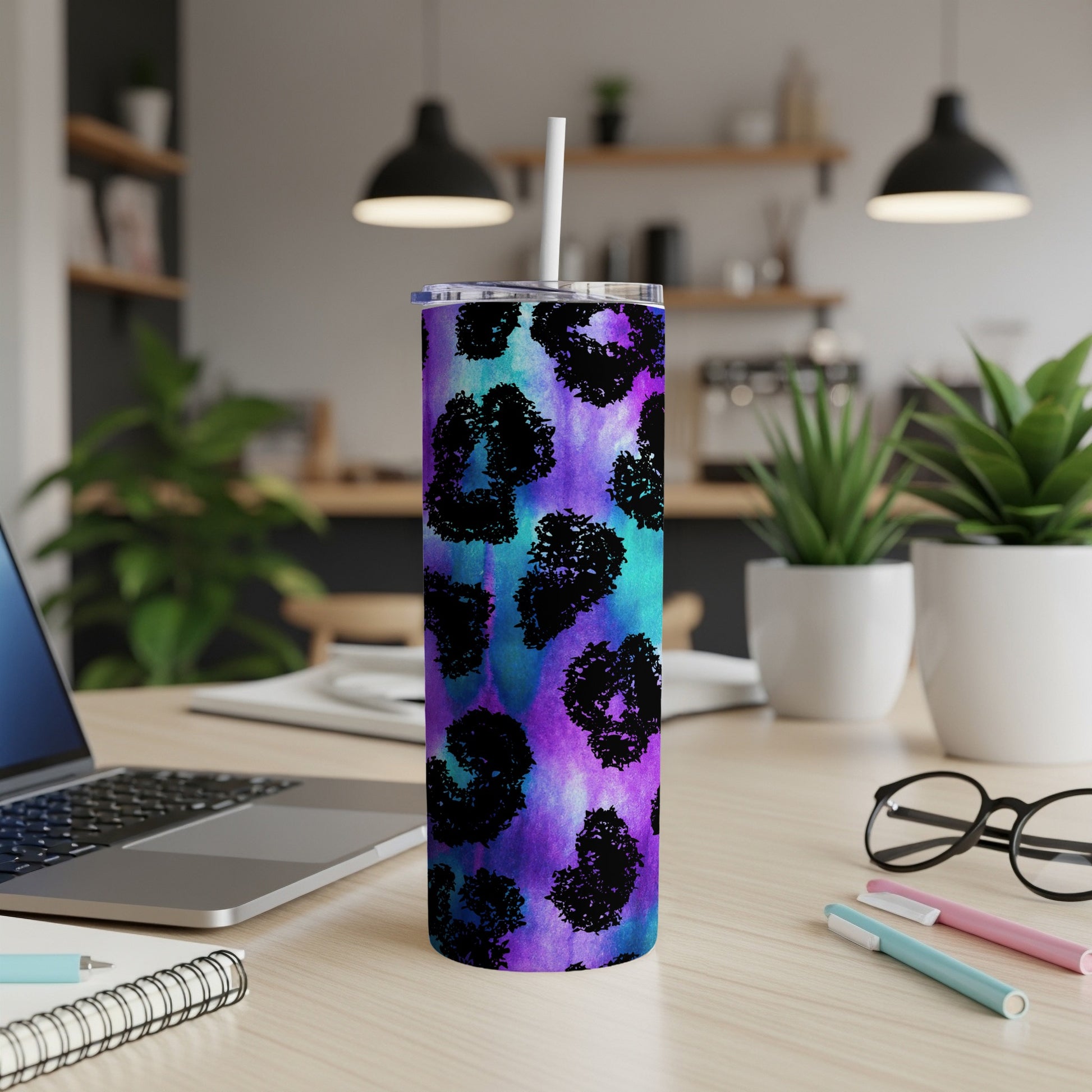 Tumbler with purple, teal, and black leopard print and a white straw.