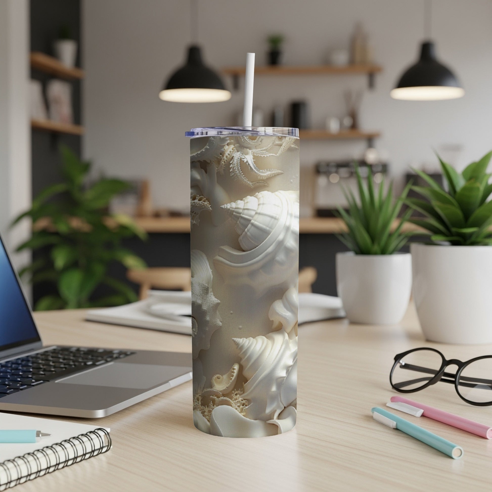 White skinny tumbler with embossed seashell pattern, straw in lid.