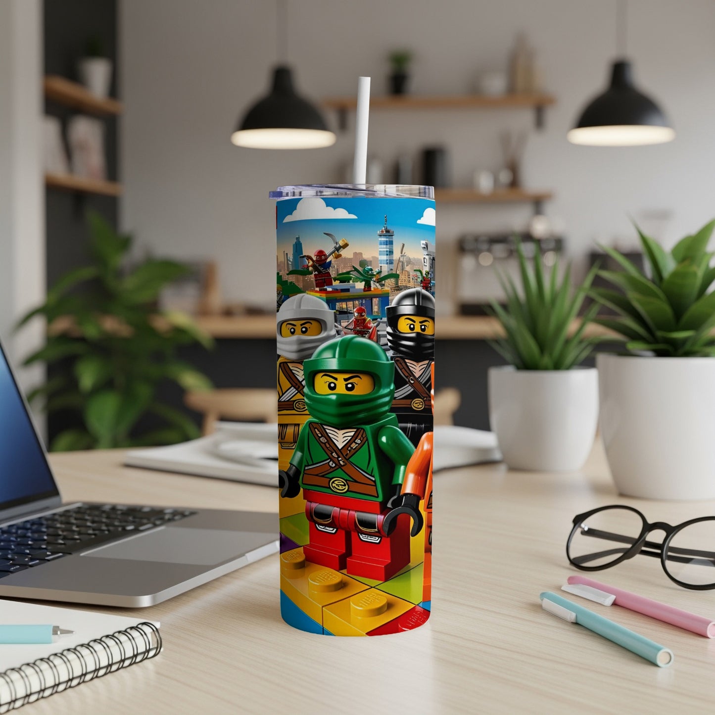 Three Lego Ninjago characters stand on colorful Lego bricks, on a desk with a laptop.