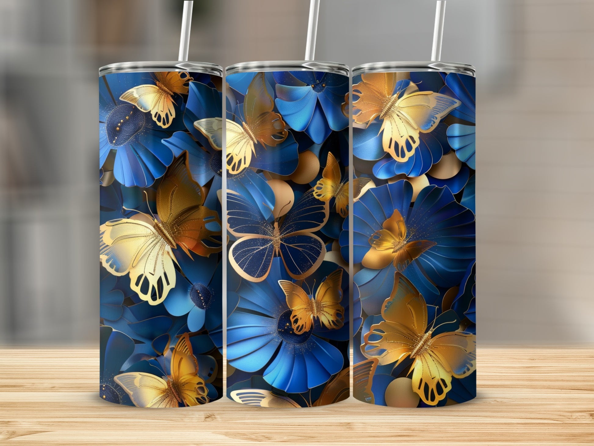 Three tumblers with gold and blue butterfly and floral designs.