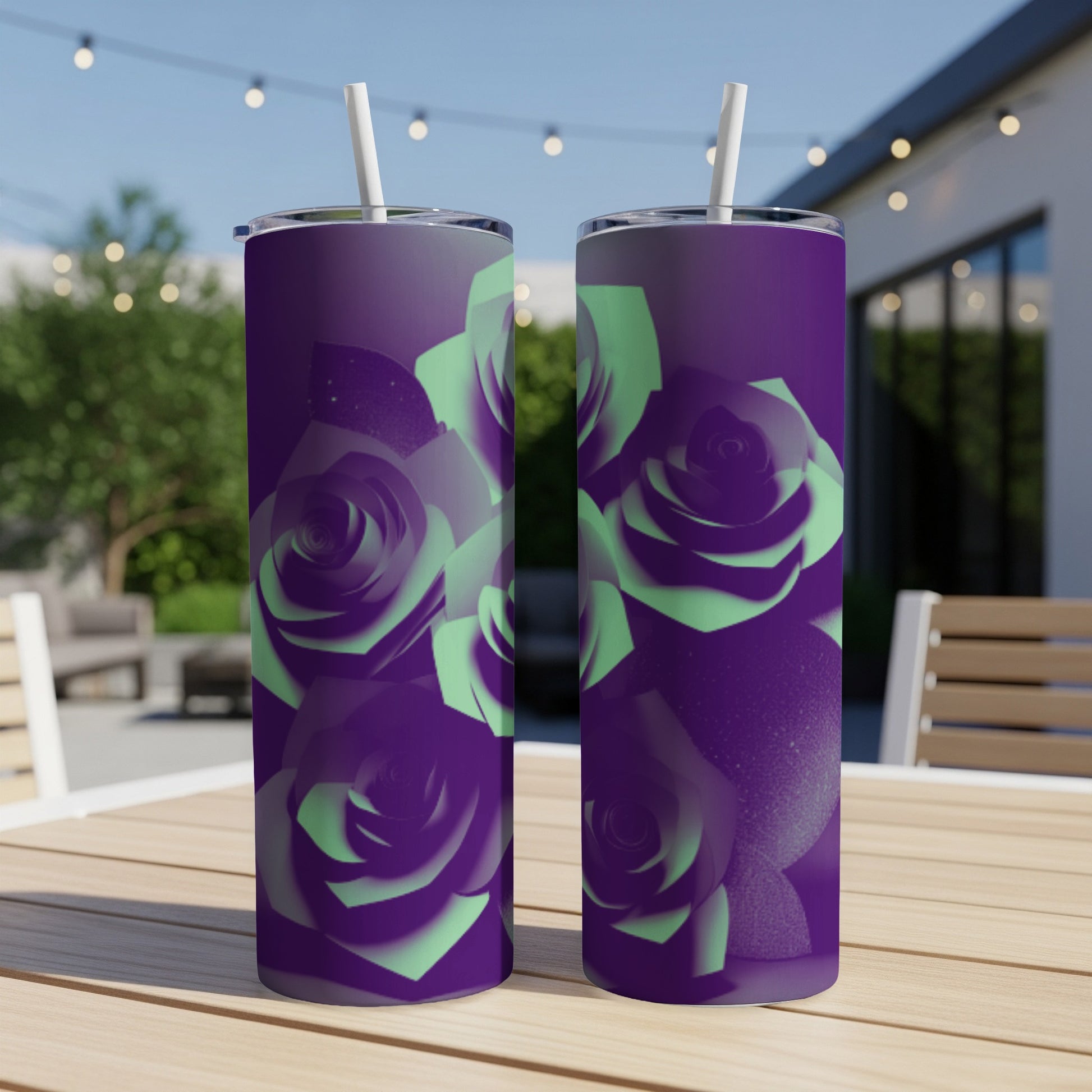 Purple tumbler with mint green roses, on a wooden table outdoors.