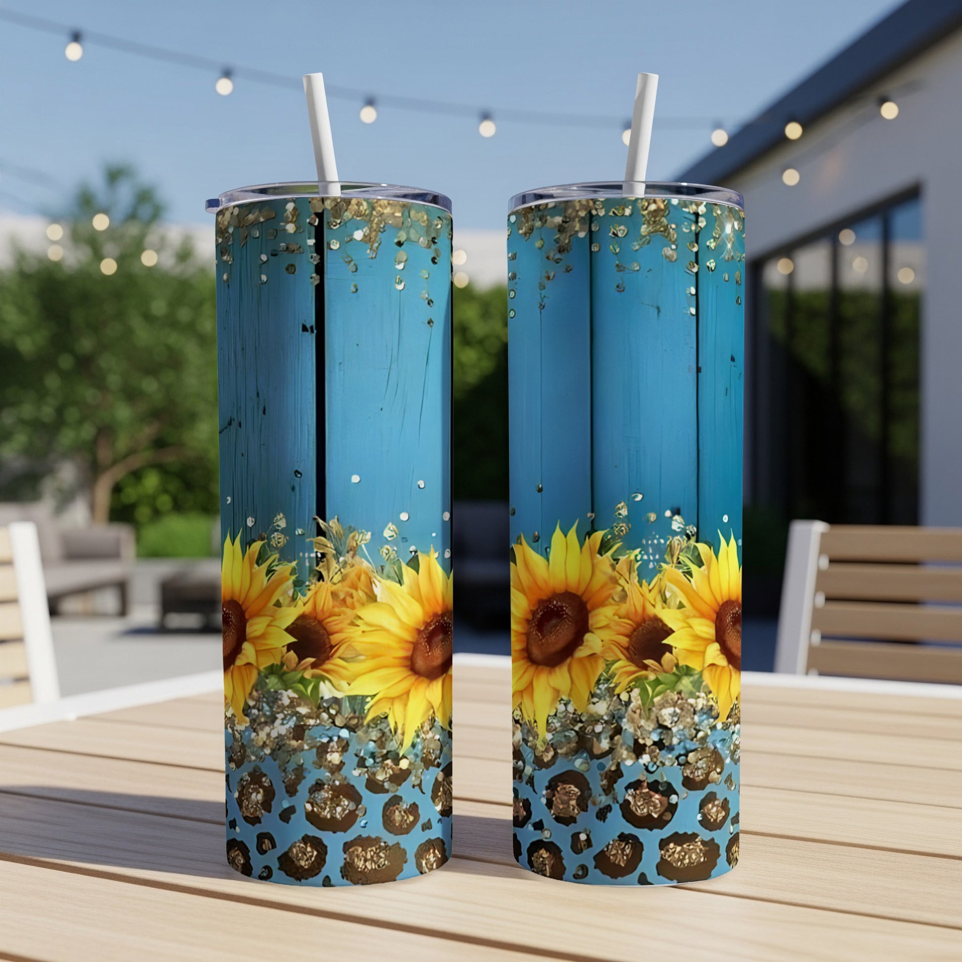 Two tall tumblers with sunflowers and leopard print on a wooden table.