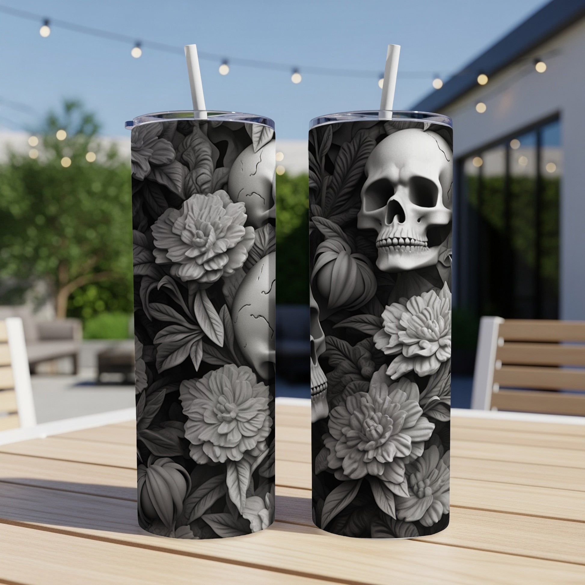Two tumblers with a skull and floral design on a table.