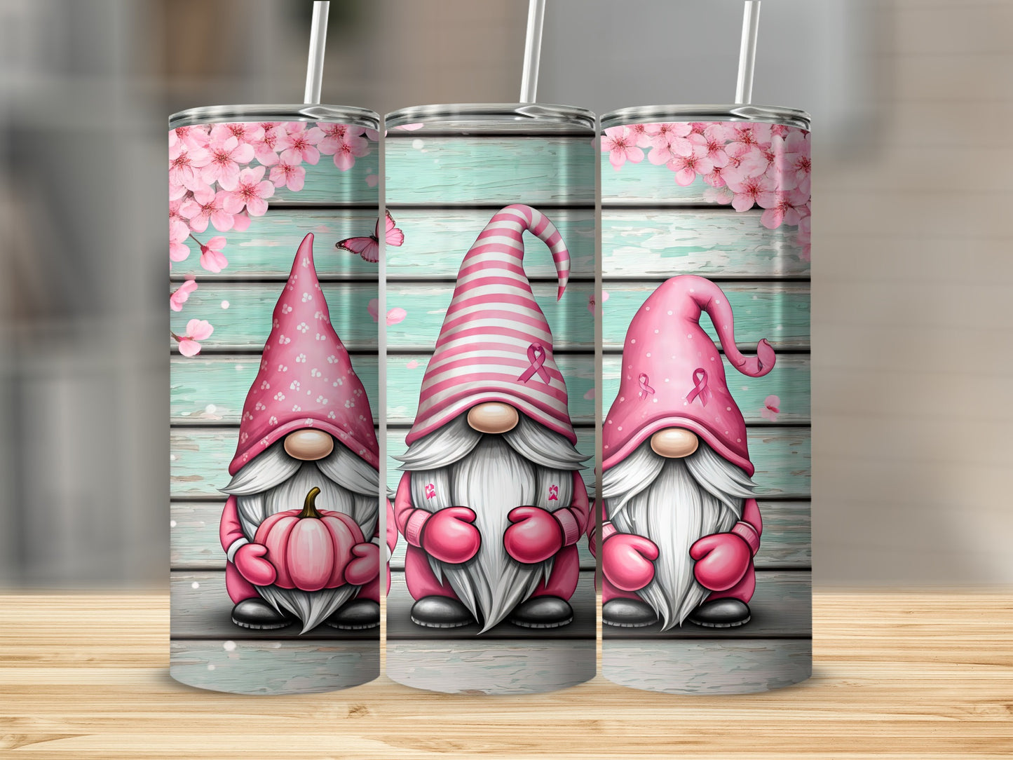 Three pink gnomes with breast cancer ribbons on a wooden background.