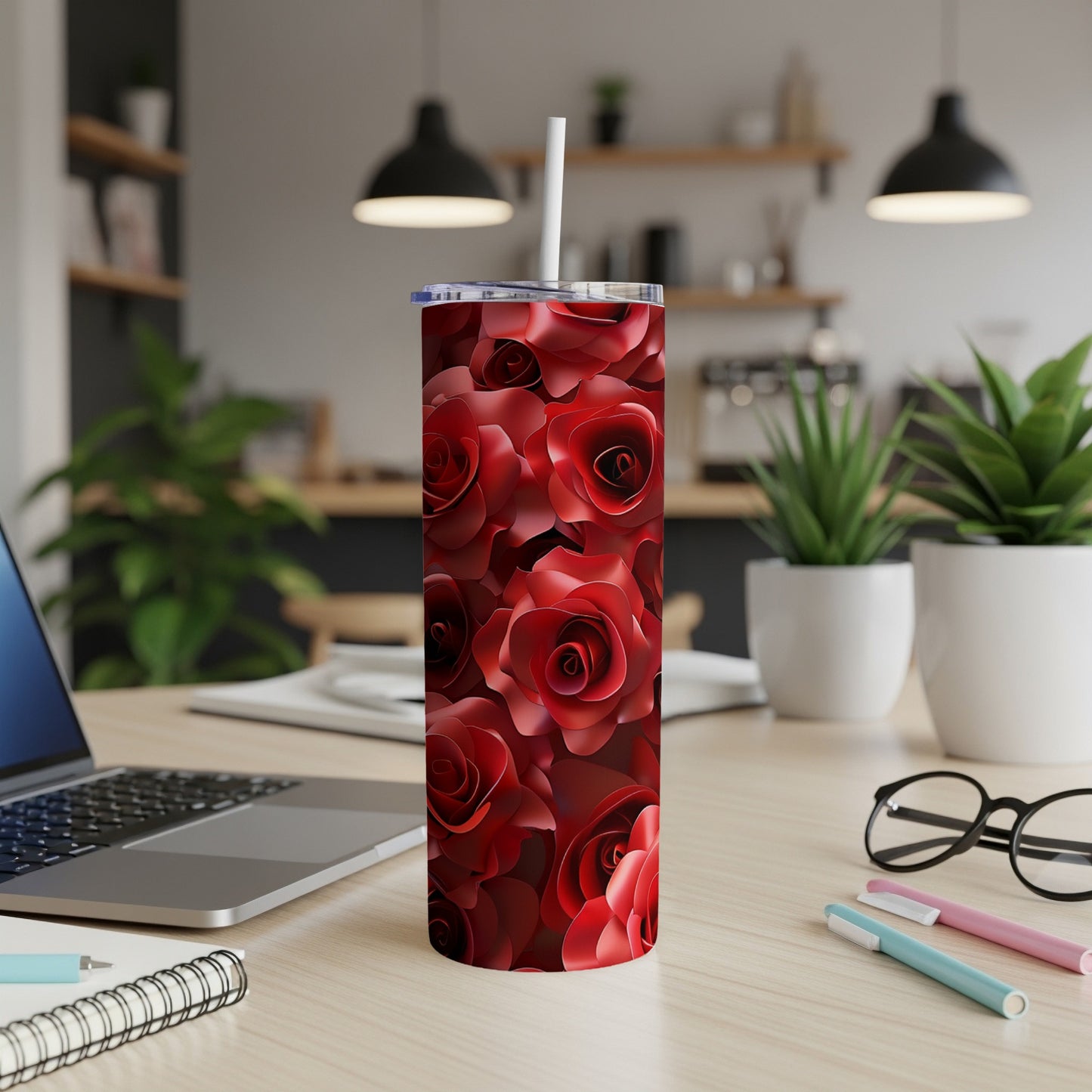 Red rose pattern skinny tumbler with straw on a desk.