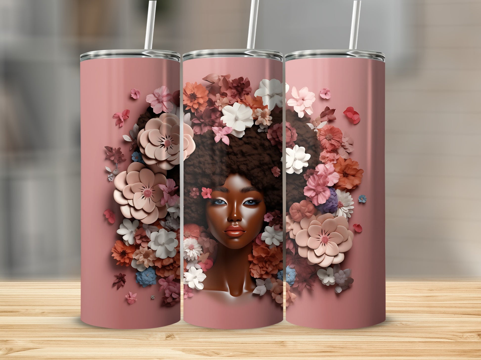 Three pink tumblers with a woman's face surrounded by floral embellishments.