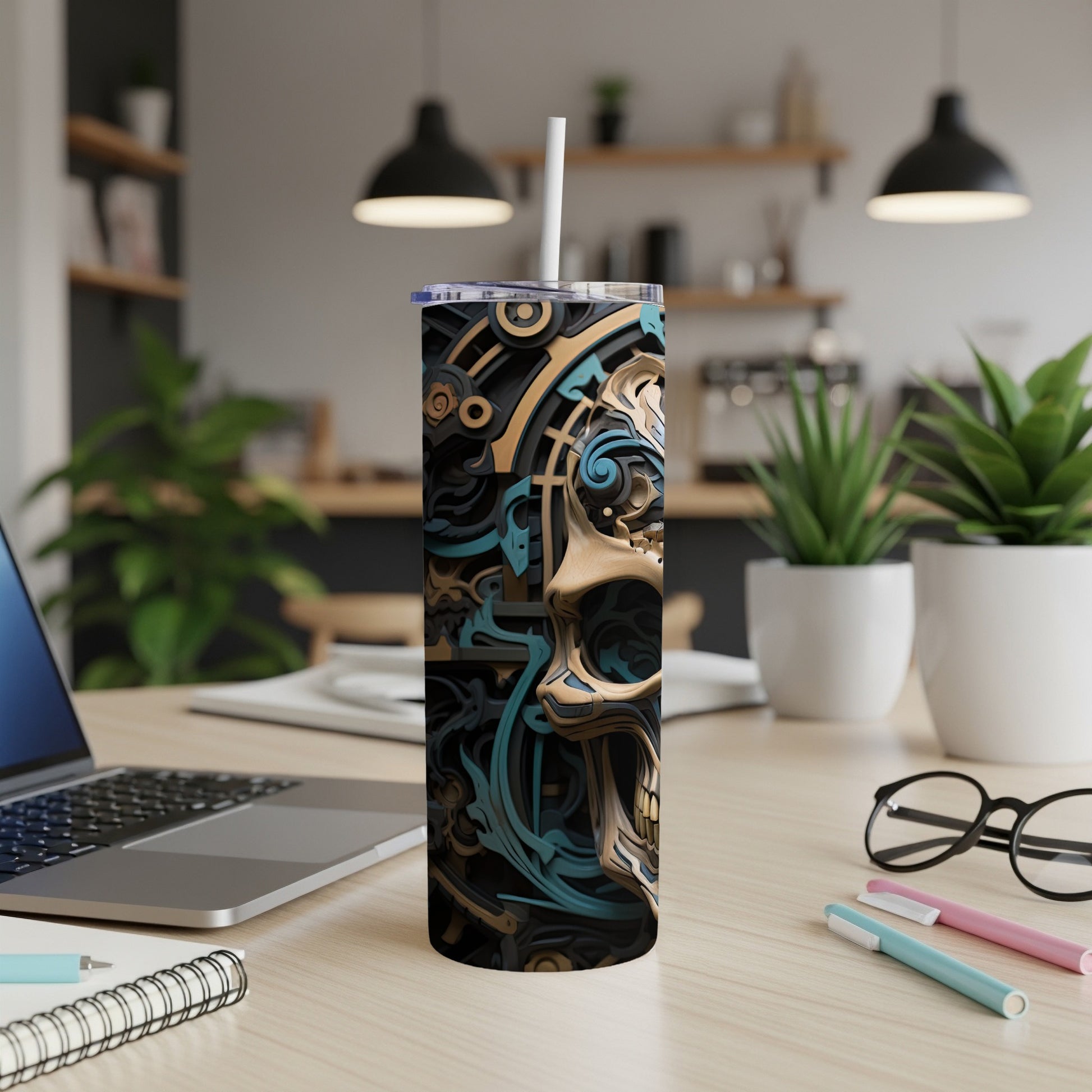 Tumbler with a black, gold, and teal abstract skull design.