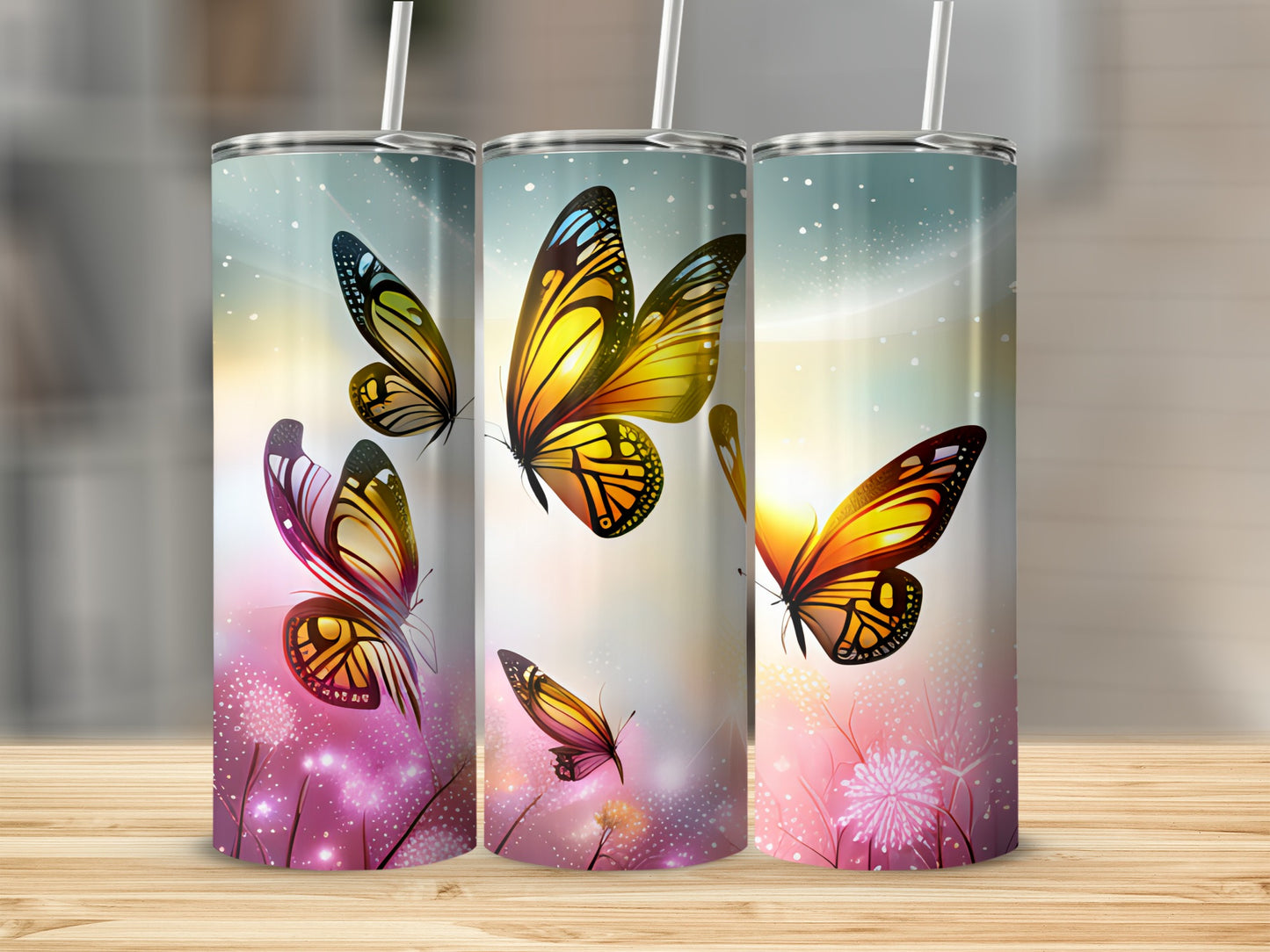 Three tumblers with vibrant butterfly designs and scattered floral elements.