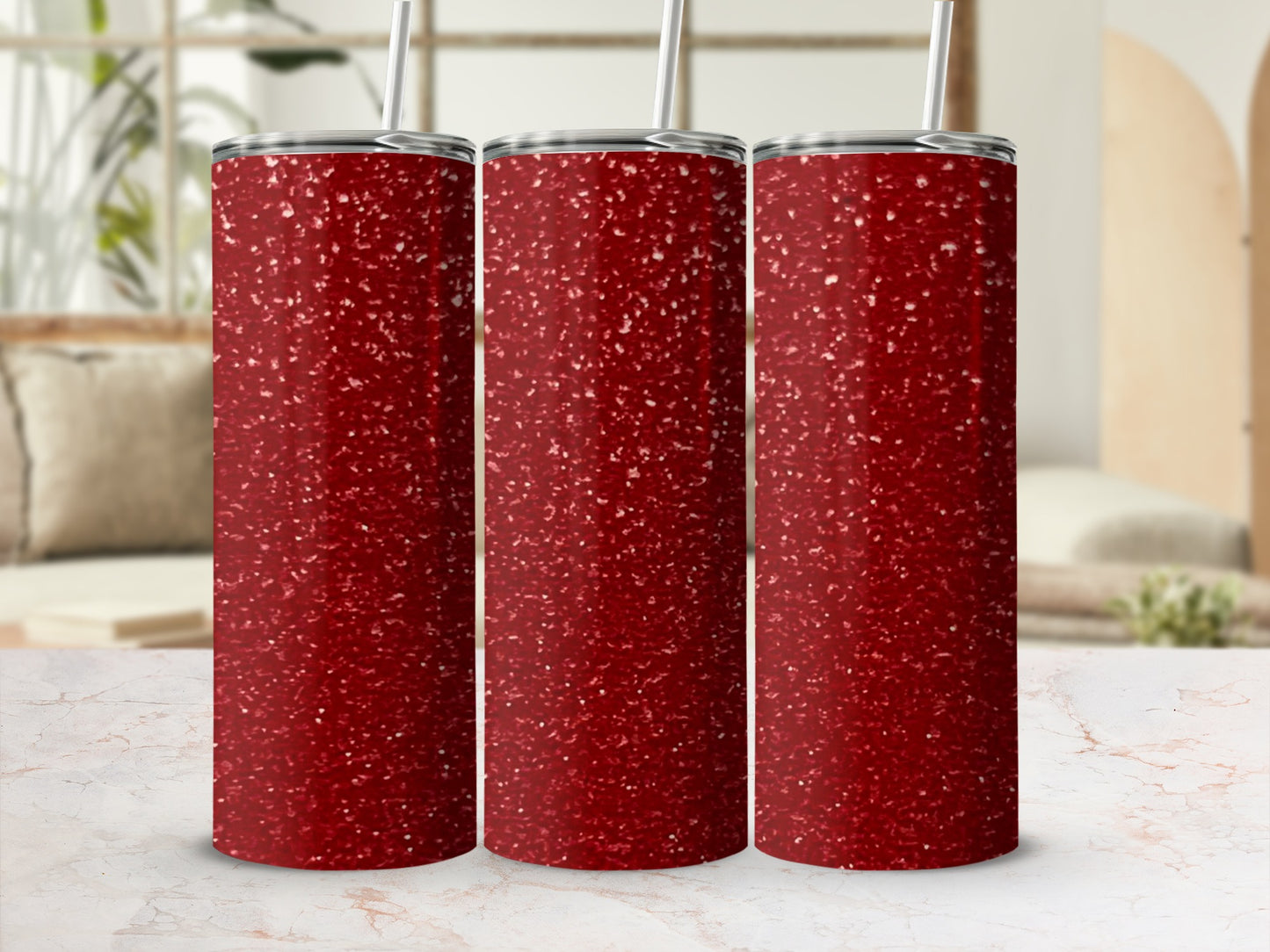Three red glitter tumblers with straws on a marble surface.