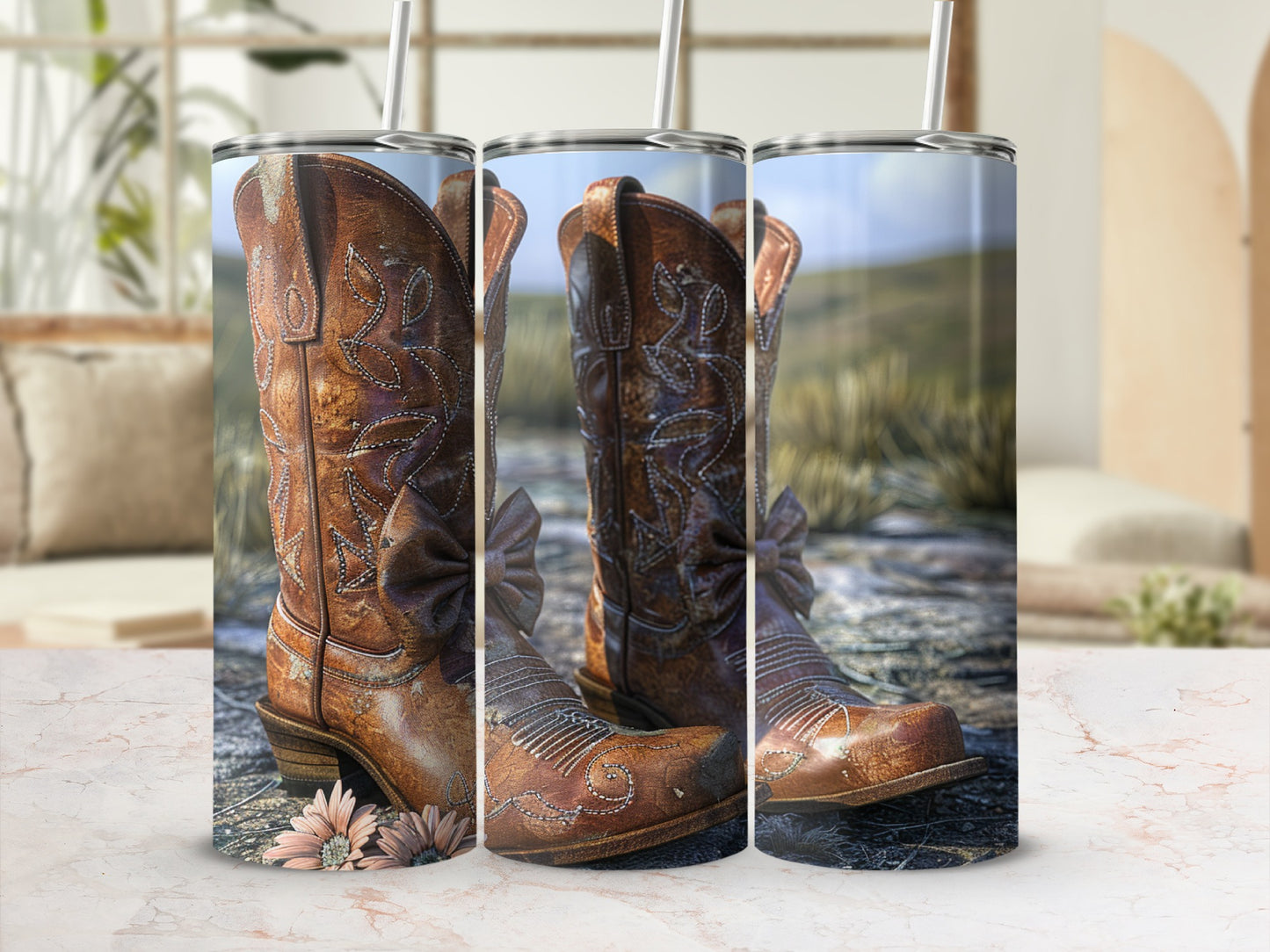 Leather cowboy boots with floral accents and straws sit on a marble surface.