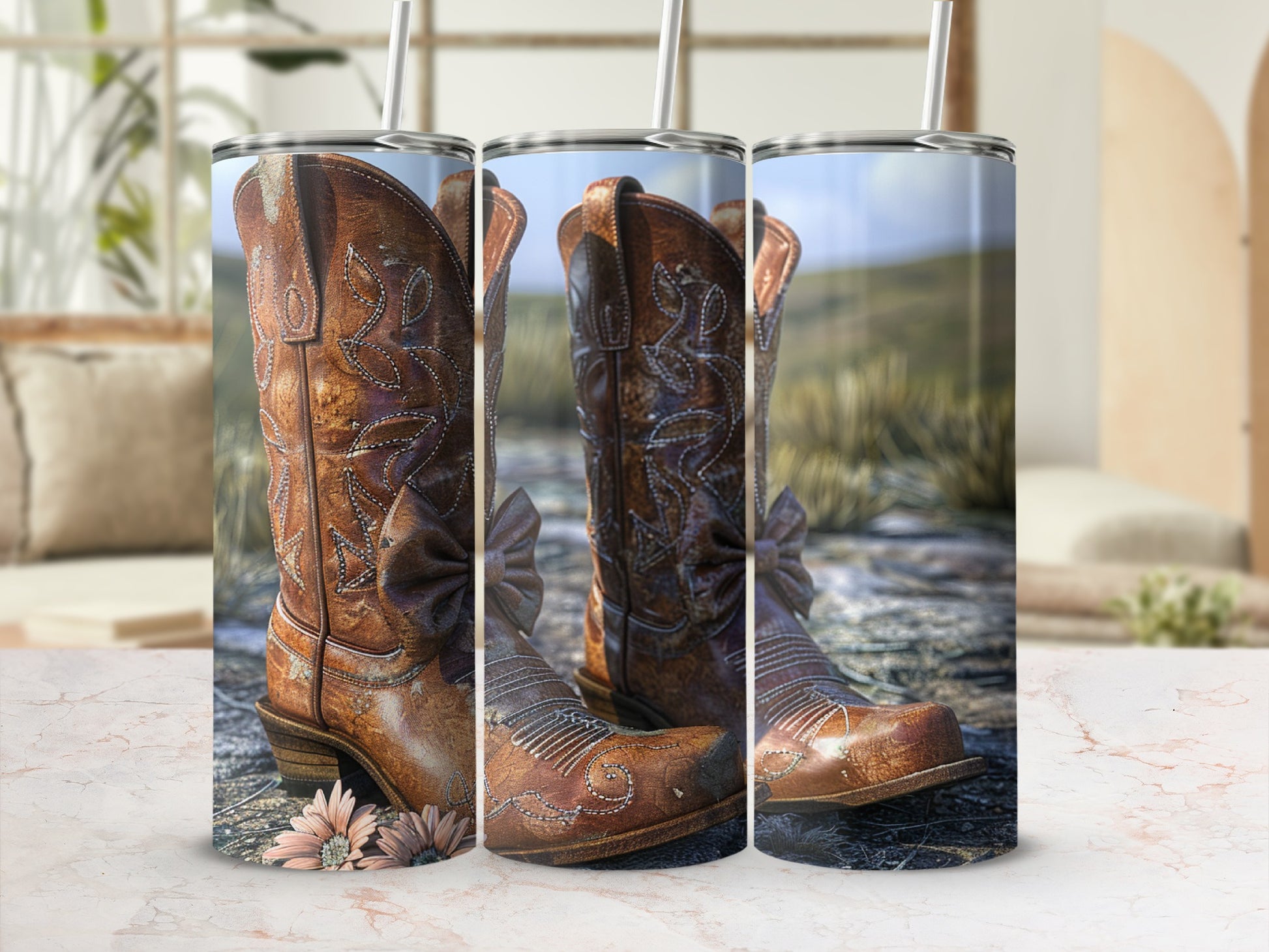 Leather cowboy boots with floral accents and straws sit on a marble surface.