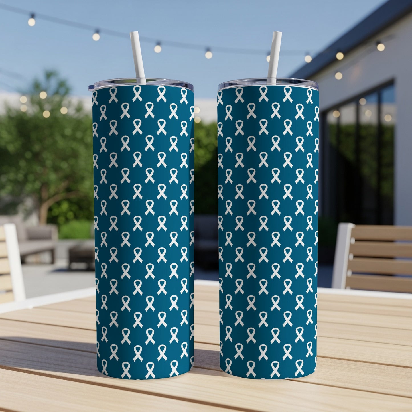 Two teal tumblers with a white ribbon pattern, each with a white straw.