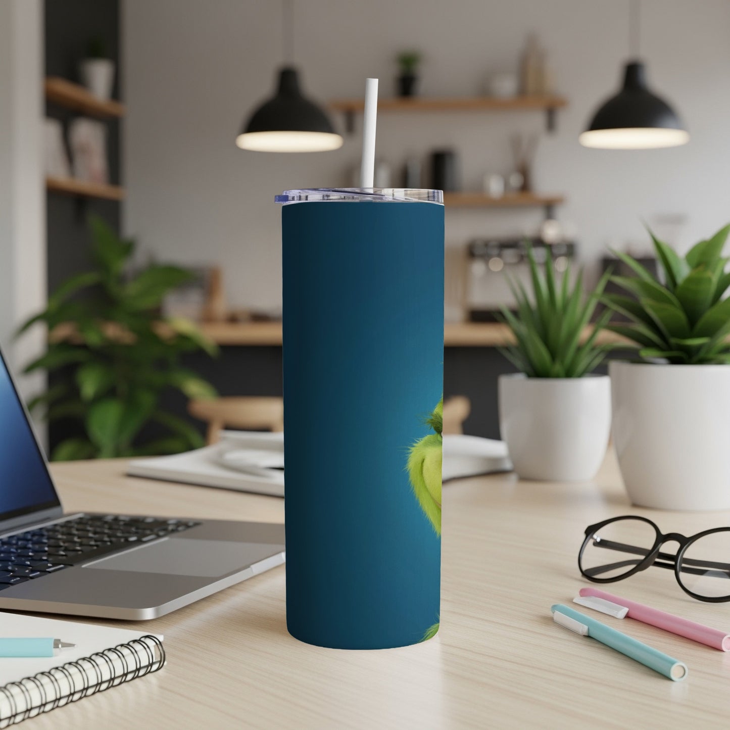 Blue tumbler featuring the Grinch with a white straw on a desk.