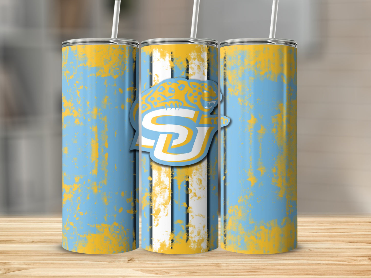 Three tumblers with blue, yellow, and white abstract distressed design; center tumbler shows logo.