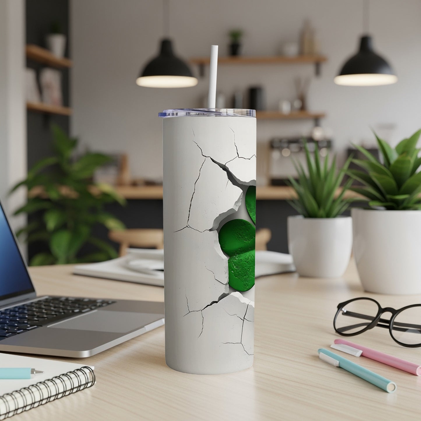 White tumbler with cracked surface revealing a green shamrock, on a desk.