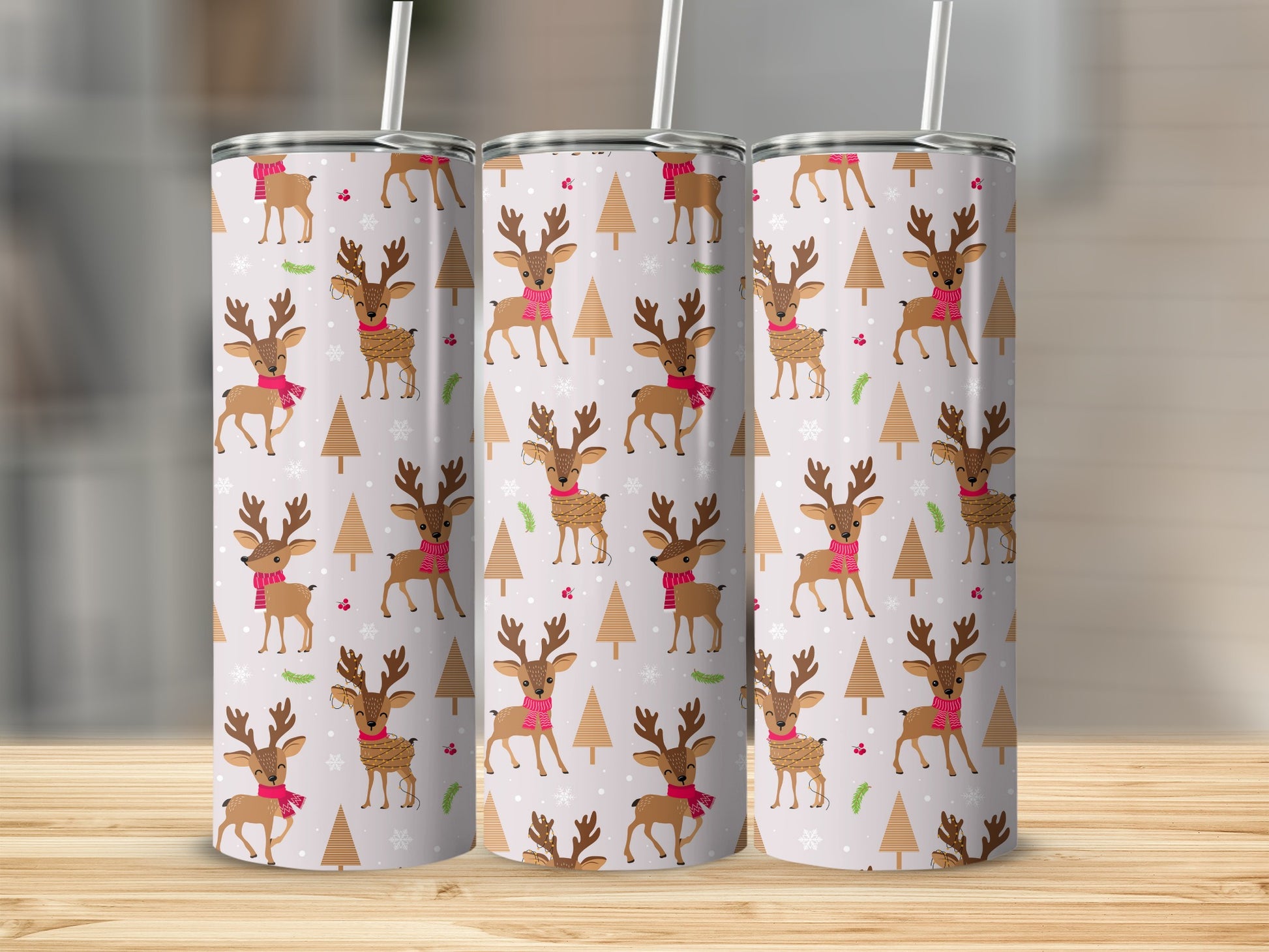 Three tumblers with a festive reindeer and Christmas tree pattern.