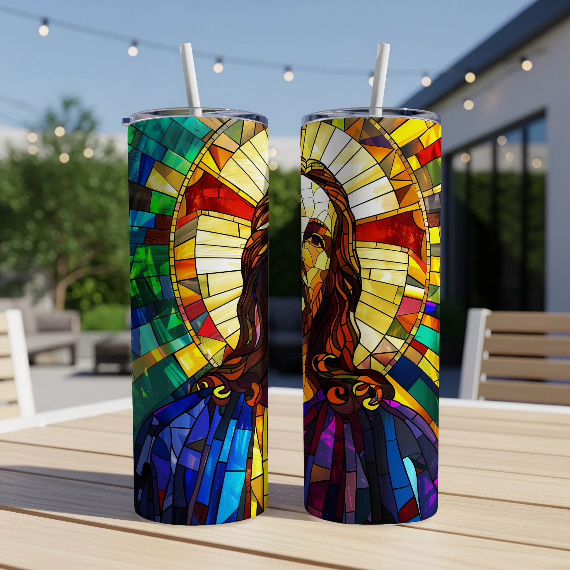 Two tumblers with stained glass imagery of Jesus Christ on a table.