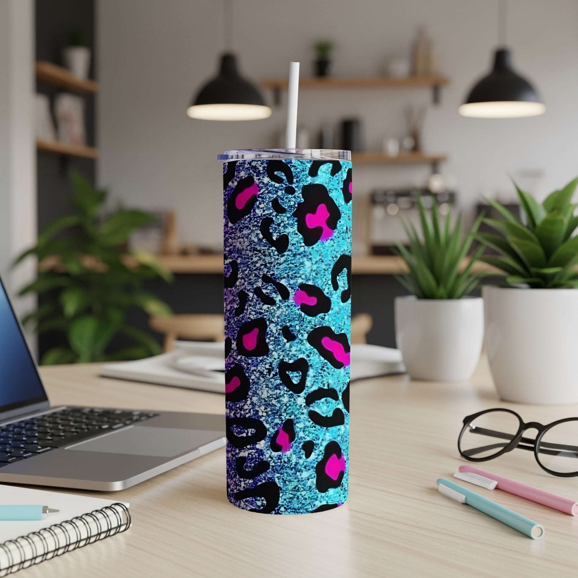 Blue and pink leopard print tumbler with straw on a desk.
