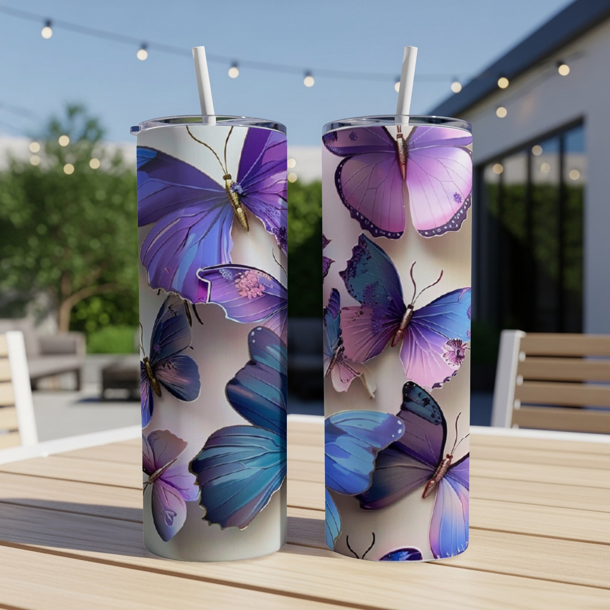 Two tumblers with vibrant purple and blue butterfly designs sit on a wooden table.