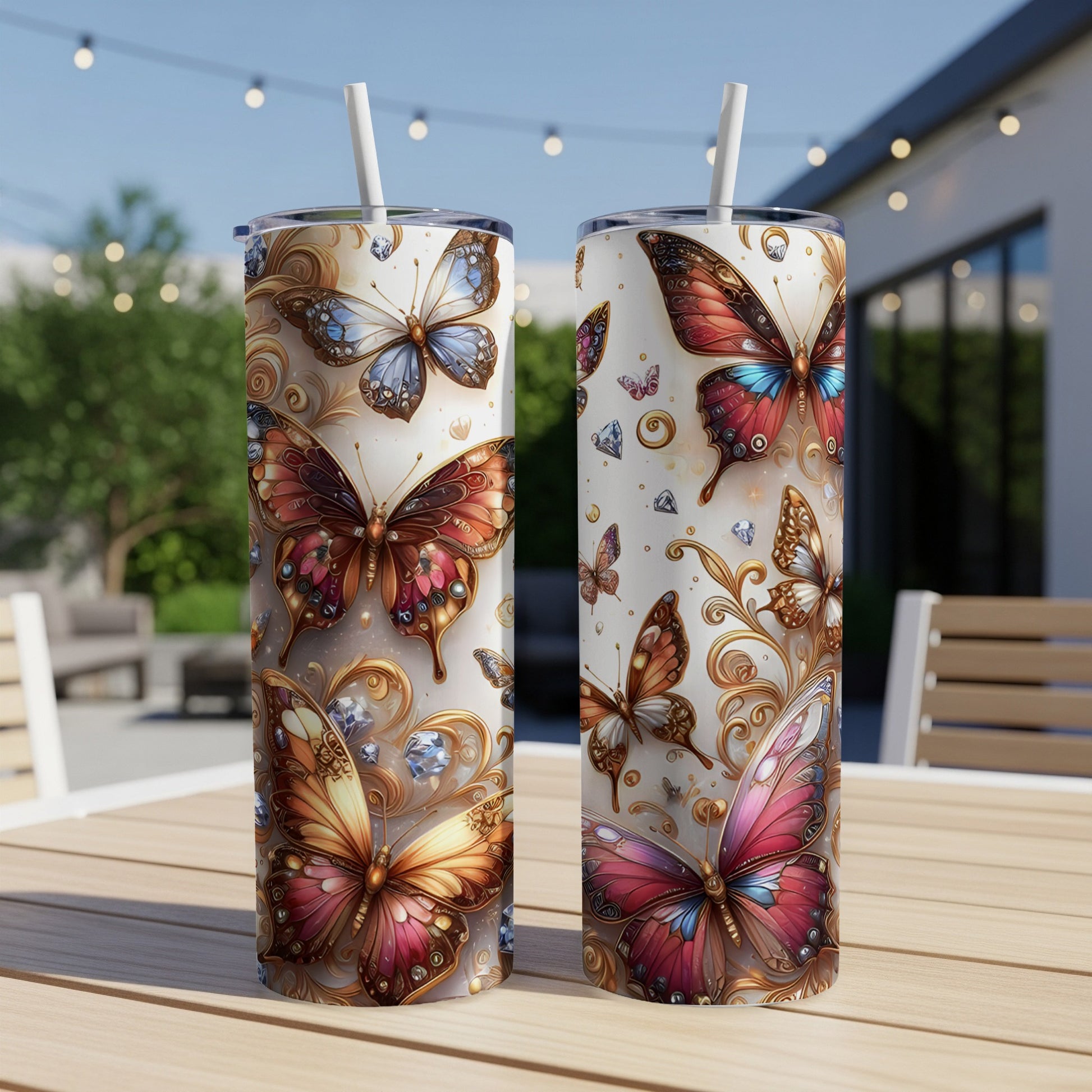 Two tumblers with colorful butterfly and gem designs sit on a wooden table.