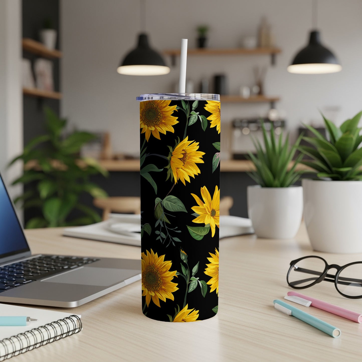 Black tumbler with a yellow sunflower pattern and a white straw.
