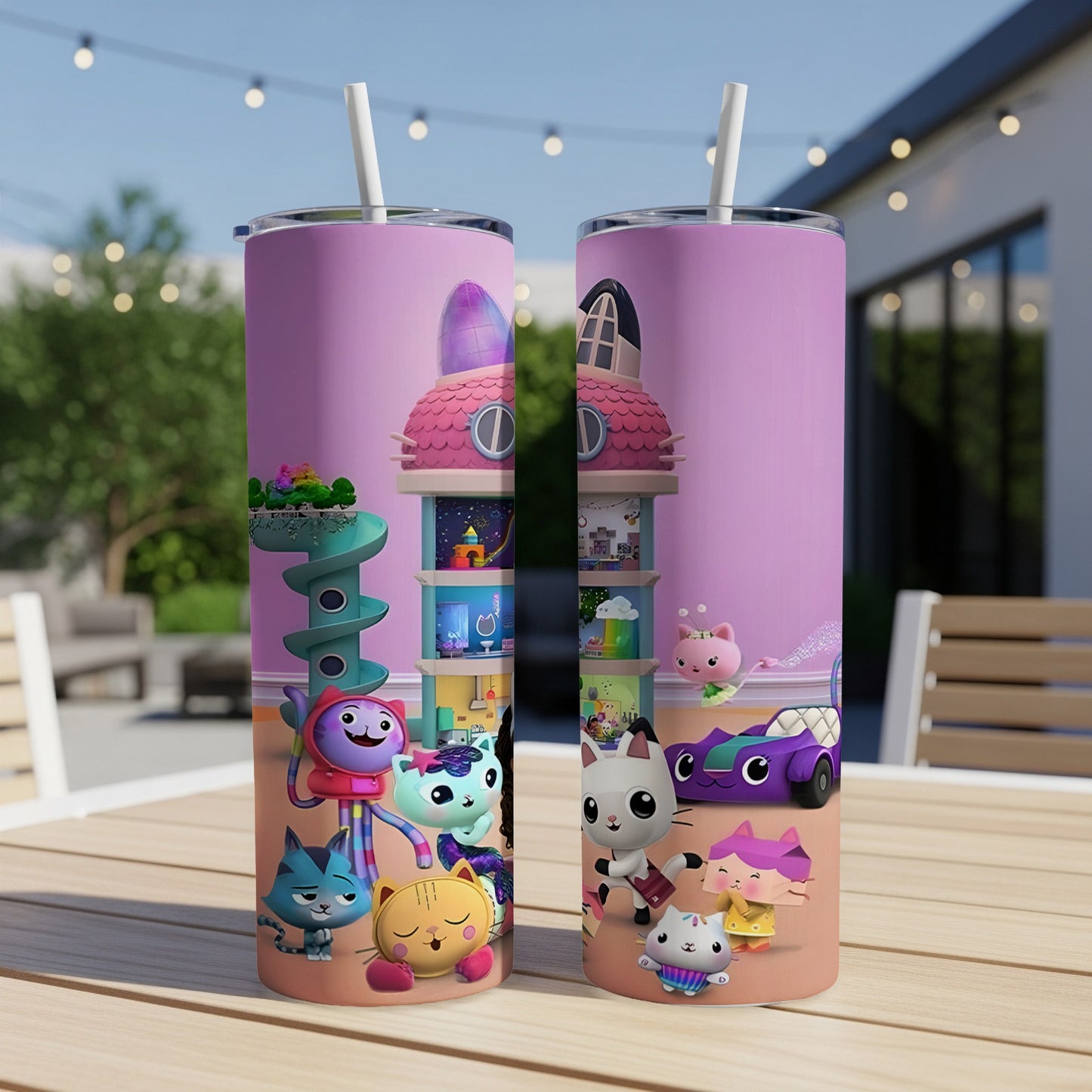 Gabby's Dollhouse characters on a pink tumbler with a straw, set on a table.