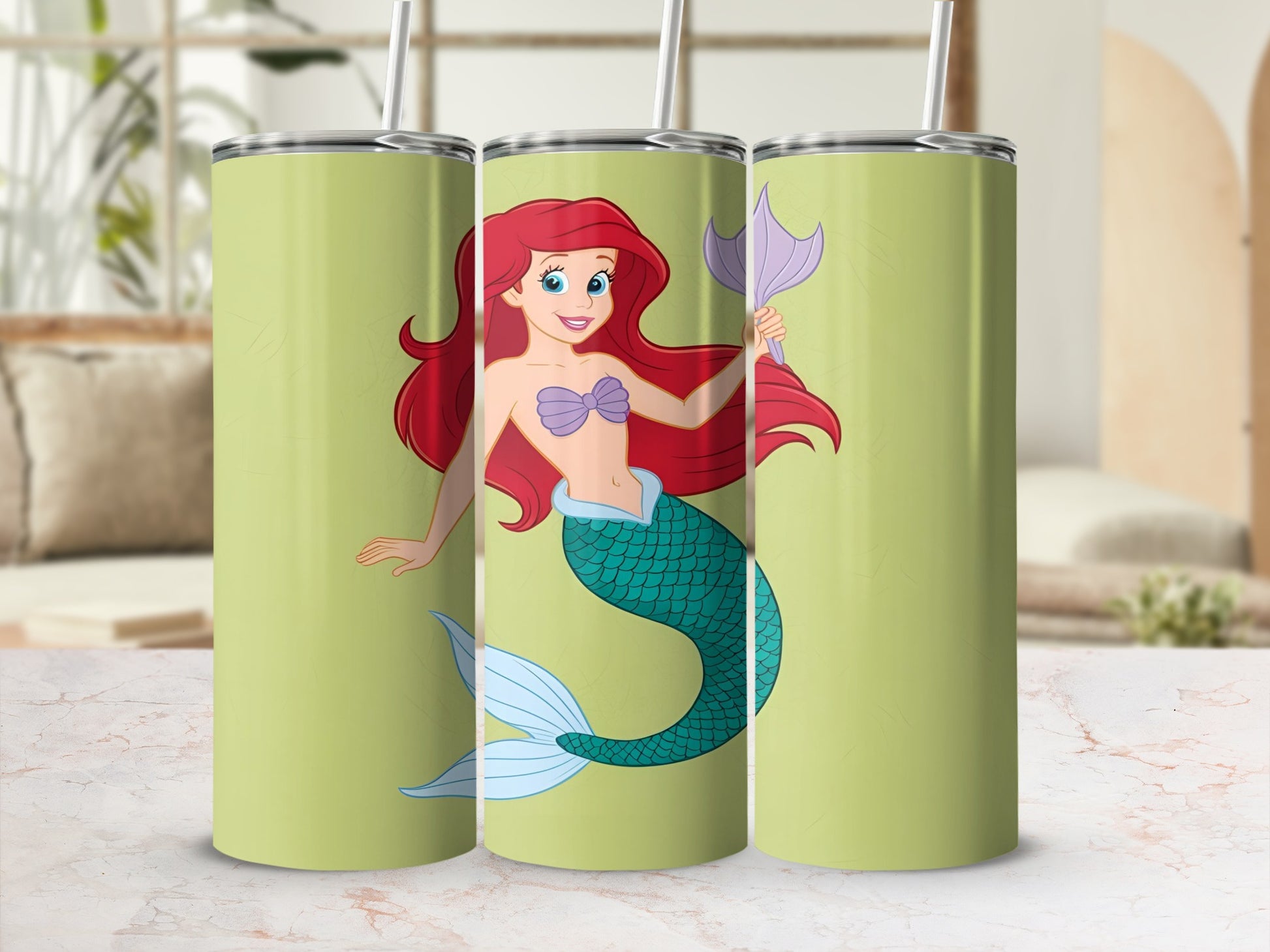 Ariel the mermaid on a pastel green tumbler with a straw.